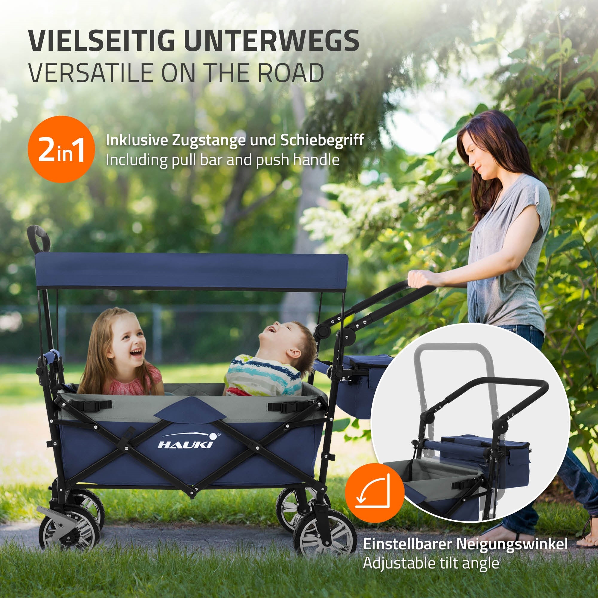 Zwei Kinder in einem Wagen mit Schiebegriff, eine Frau steht daneben.