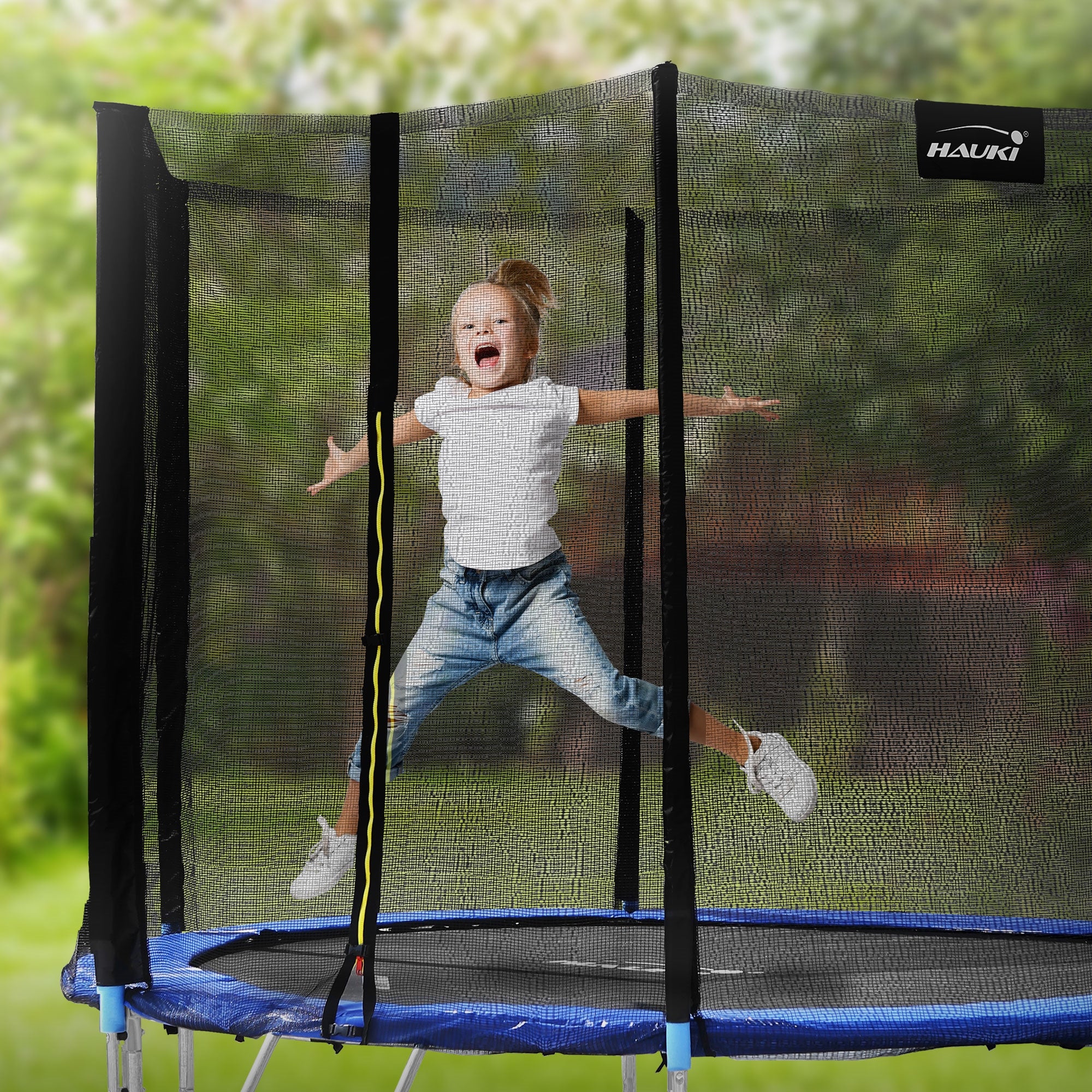Kind springt fröhlich auf einem Trampolin mit Sicherheitsnetz im Freien.