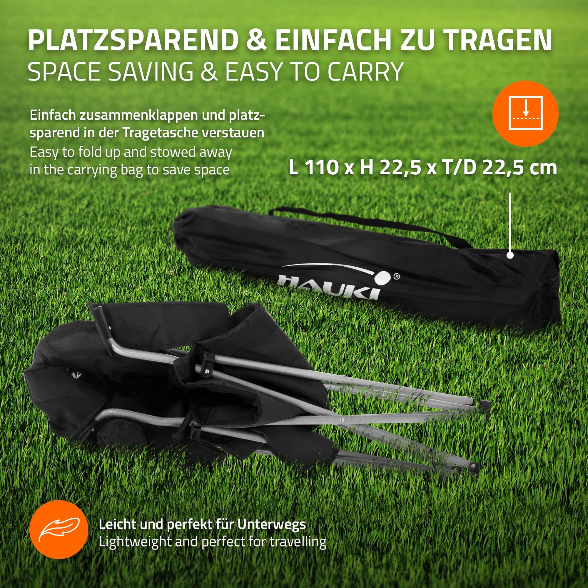 Ein zusammengeklappter Klappstuhl in einer Tragetasche auf grünem Gras.