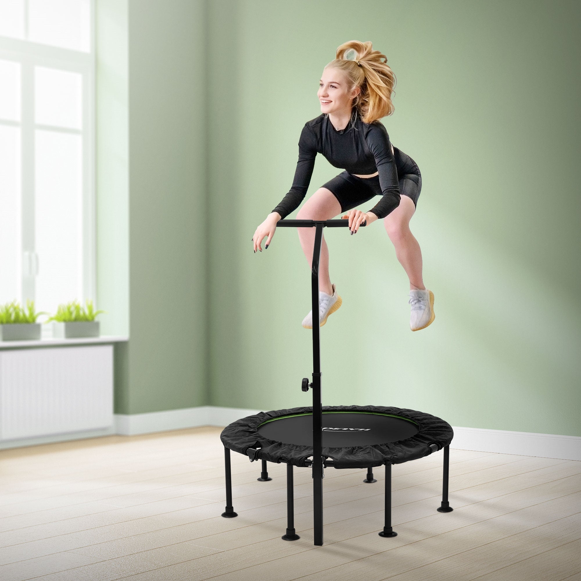 Frau springt auf einem Trampolin mit Sicherheitsgriff.