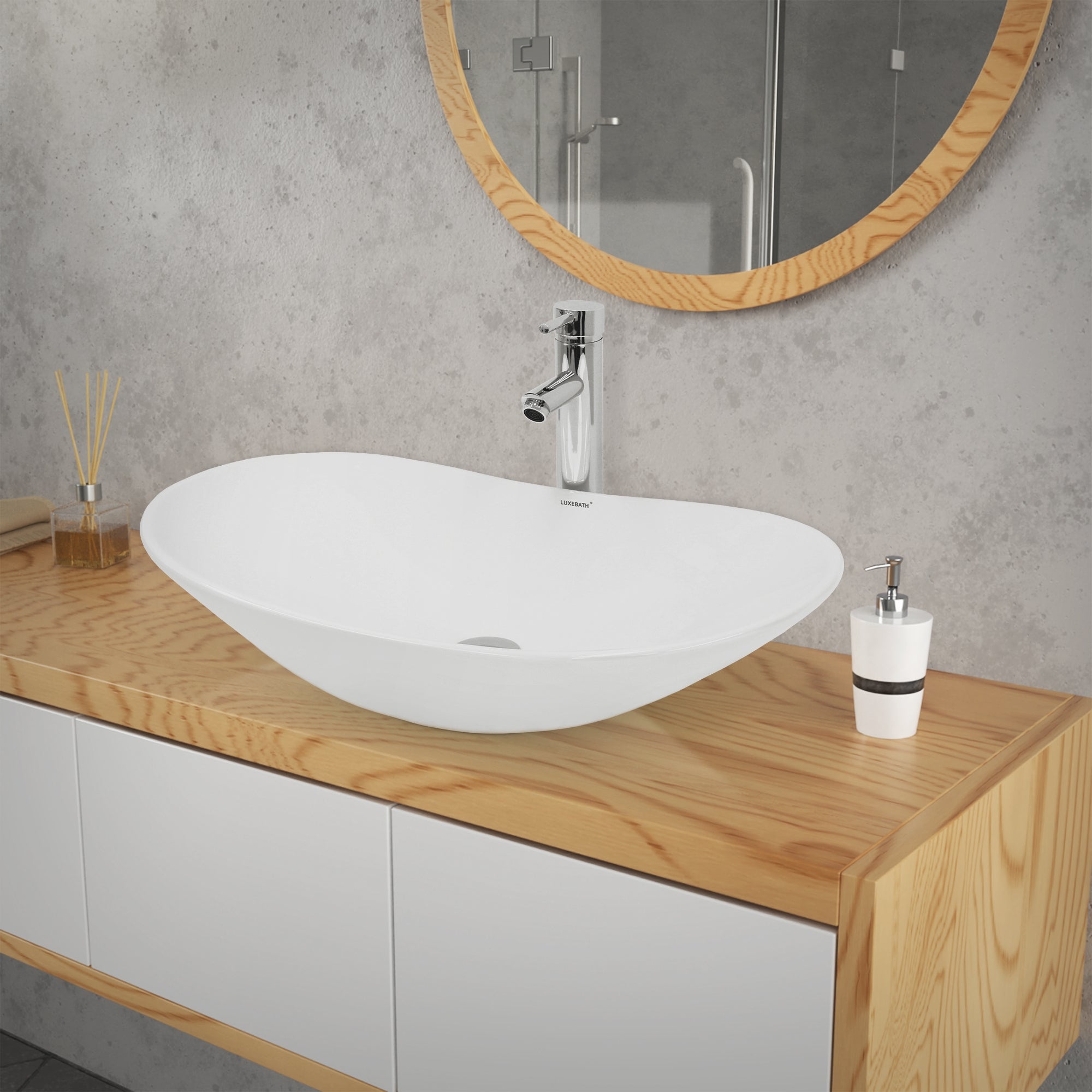Organically shaped, white sink on a wooden shelf.