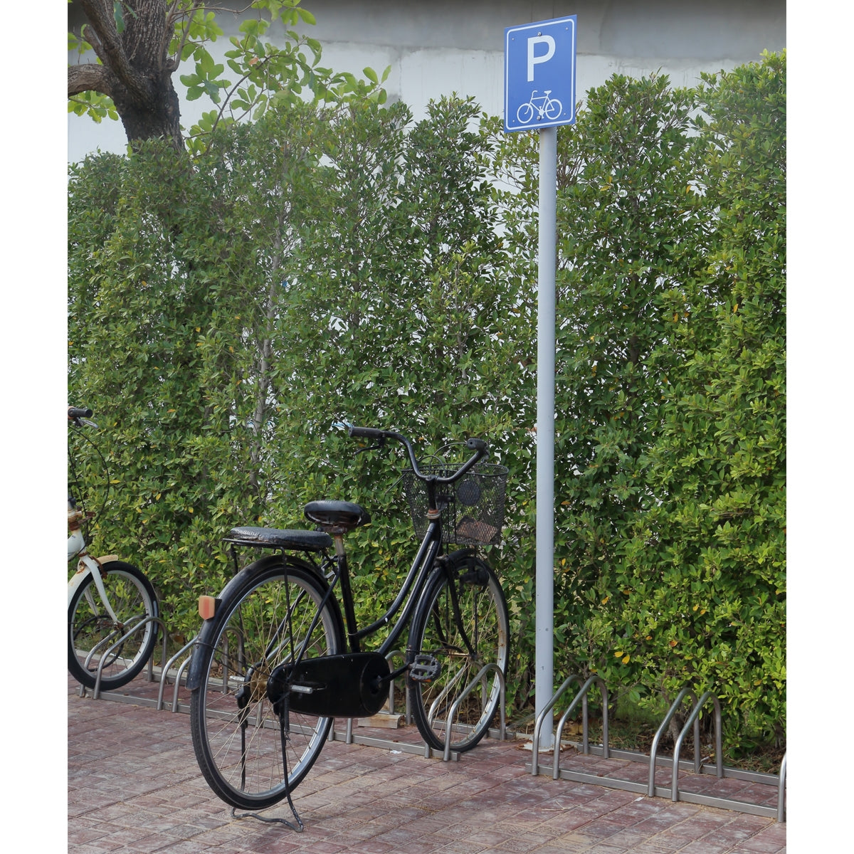 Fahrradparkplatz mit einem Schild und mehreren Fahrrädern.