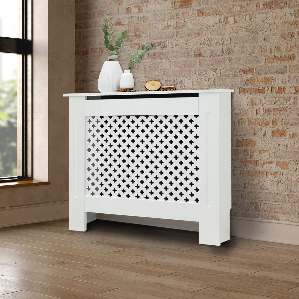 Witte radiatorbekleding voor een bakstenen muur met planten.
