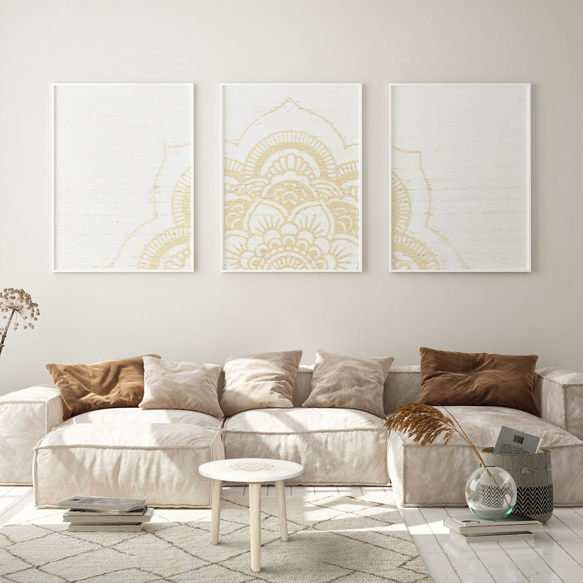 Wohnzimmer mit drei Bildern und beigem Sofa.