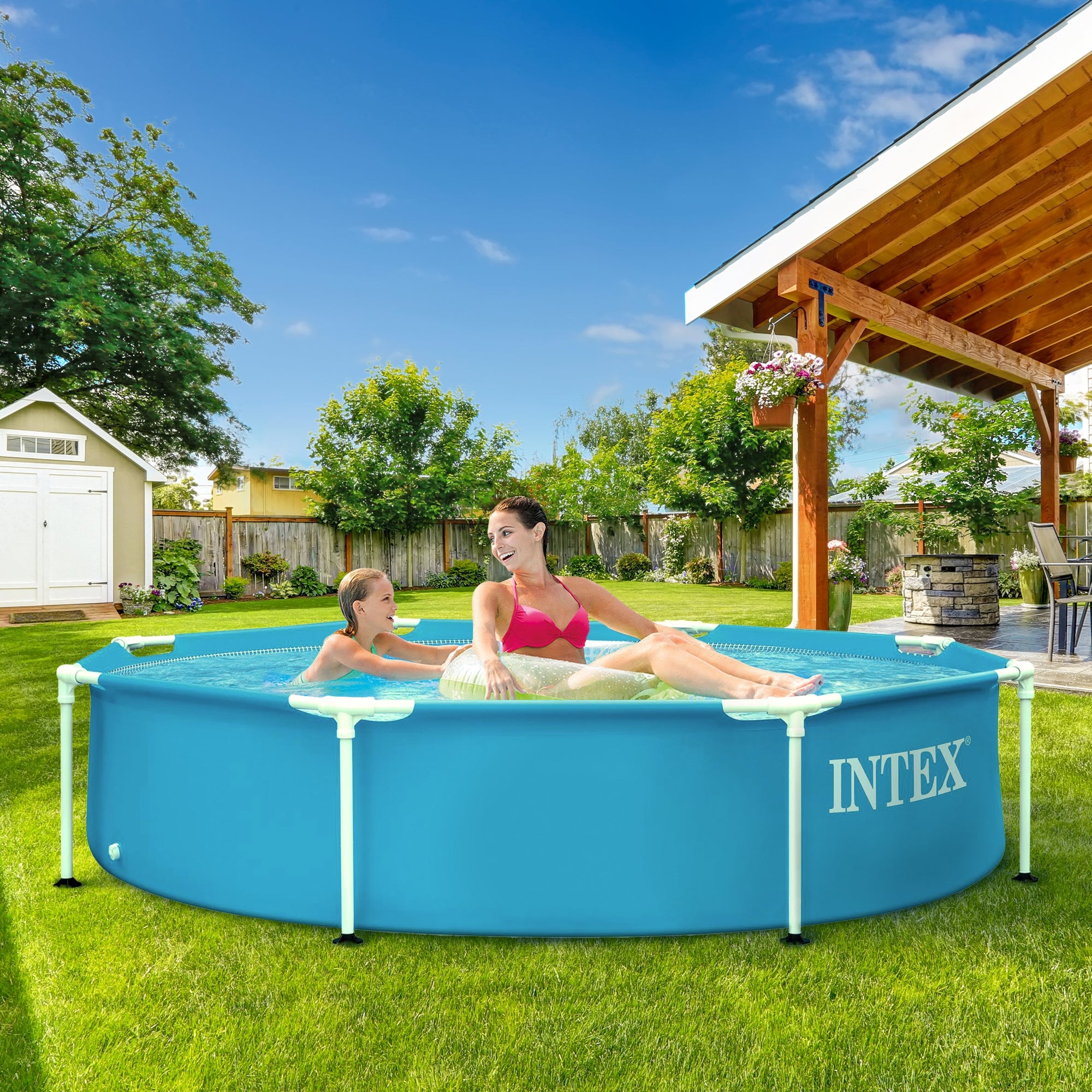 Eine Frau und ein Kind entspannen in einem runden Pool im Garten.