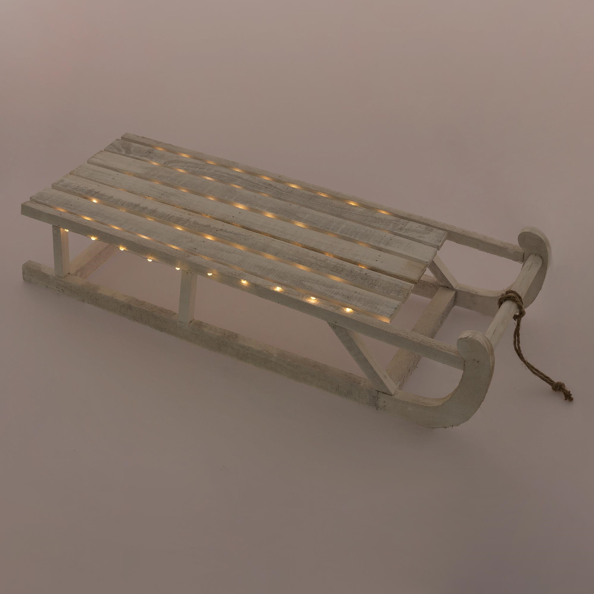 Luge en bois avec des lumières sur un fond uni.