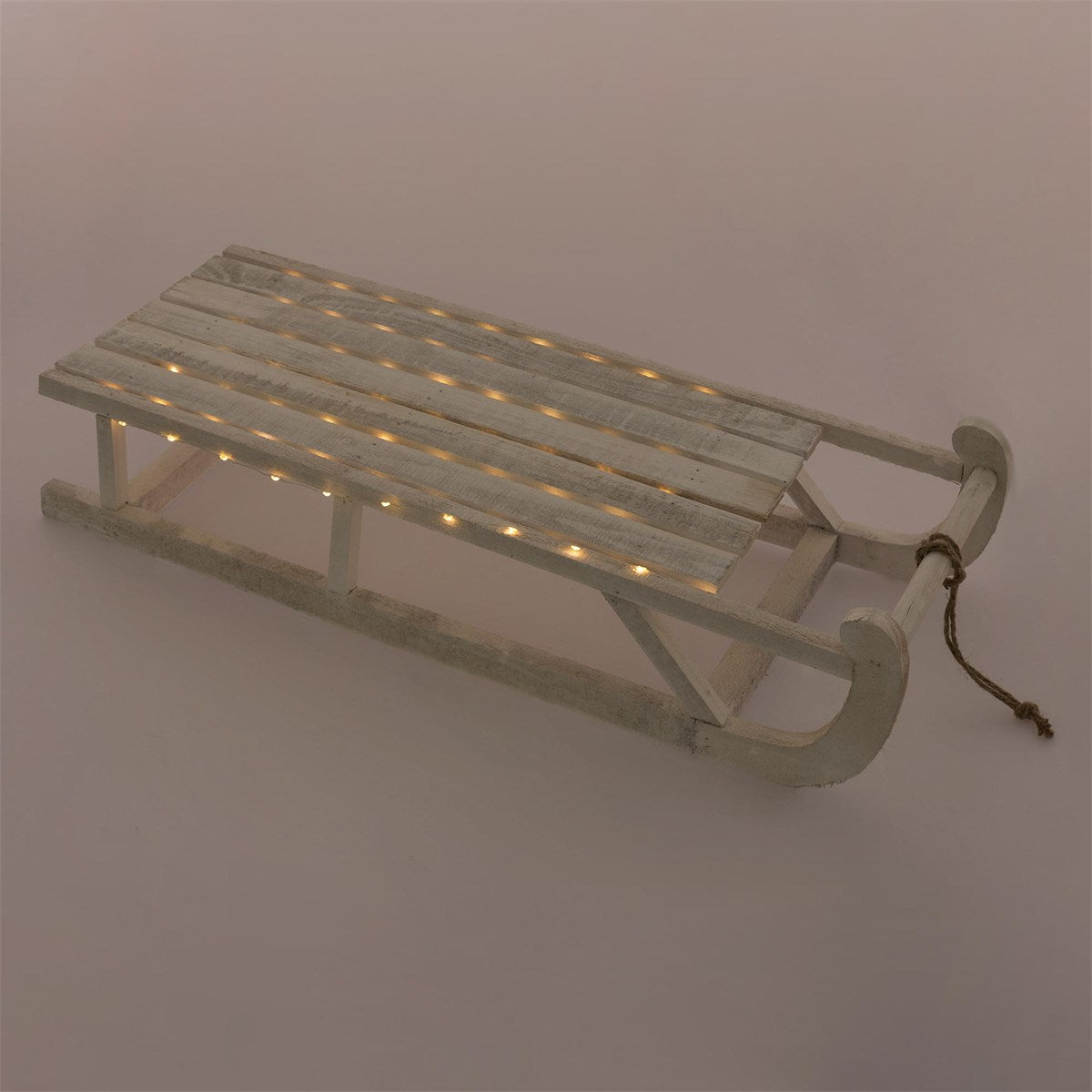 Wooden sled with lights on a solid-colored background.