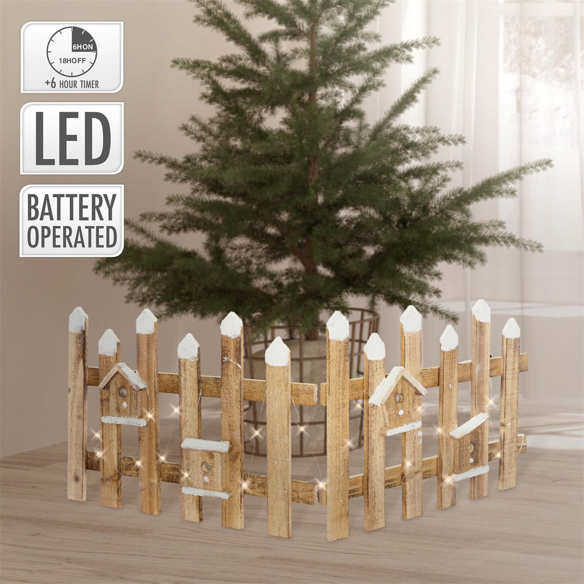 Holzzaun um einen Weihnachtsbaum, mit Lichtern, in einem Raum.