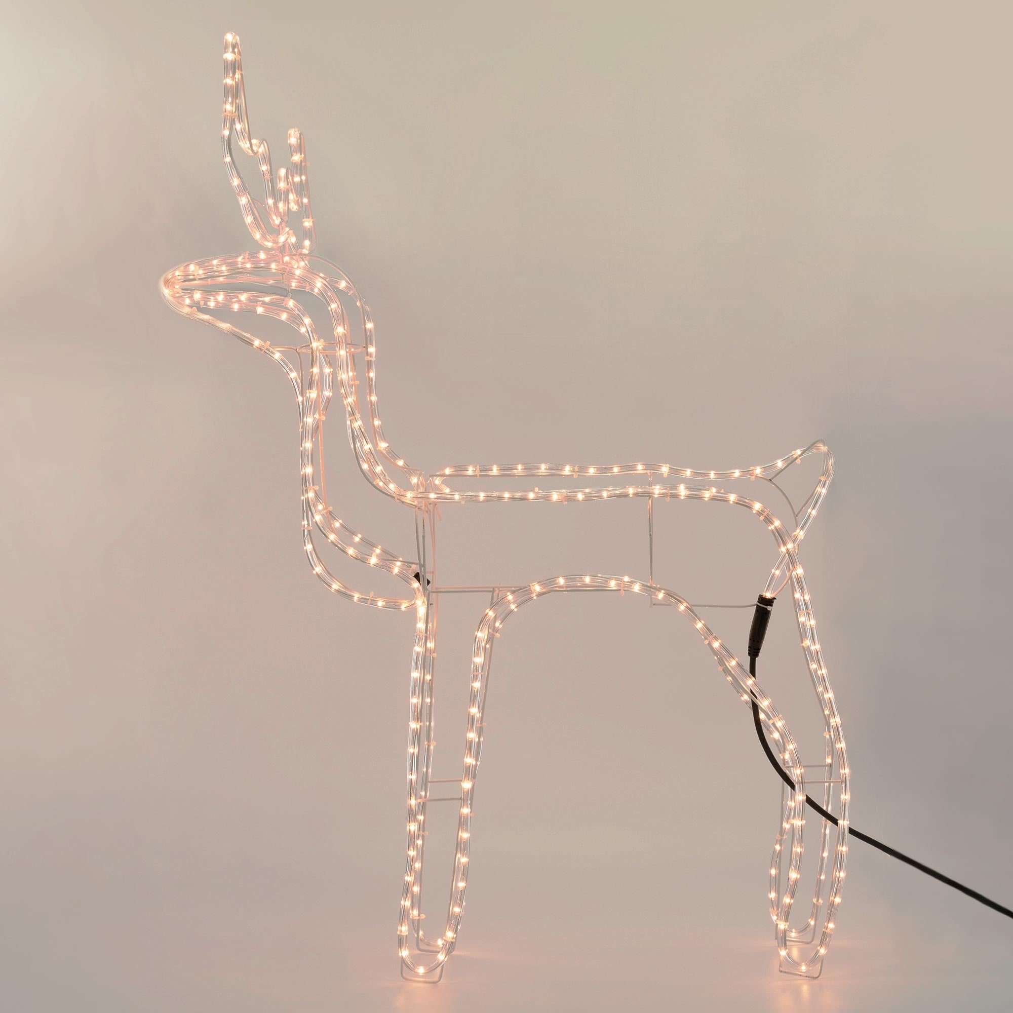 An illuminated reindeer made of wire with lights.