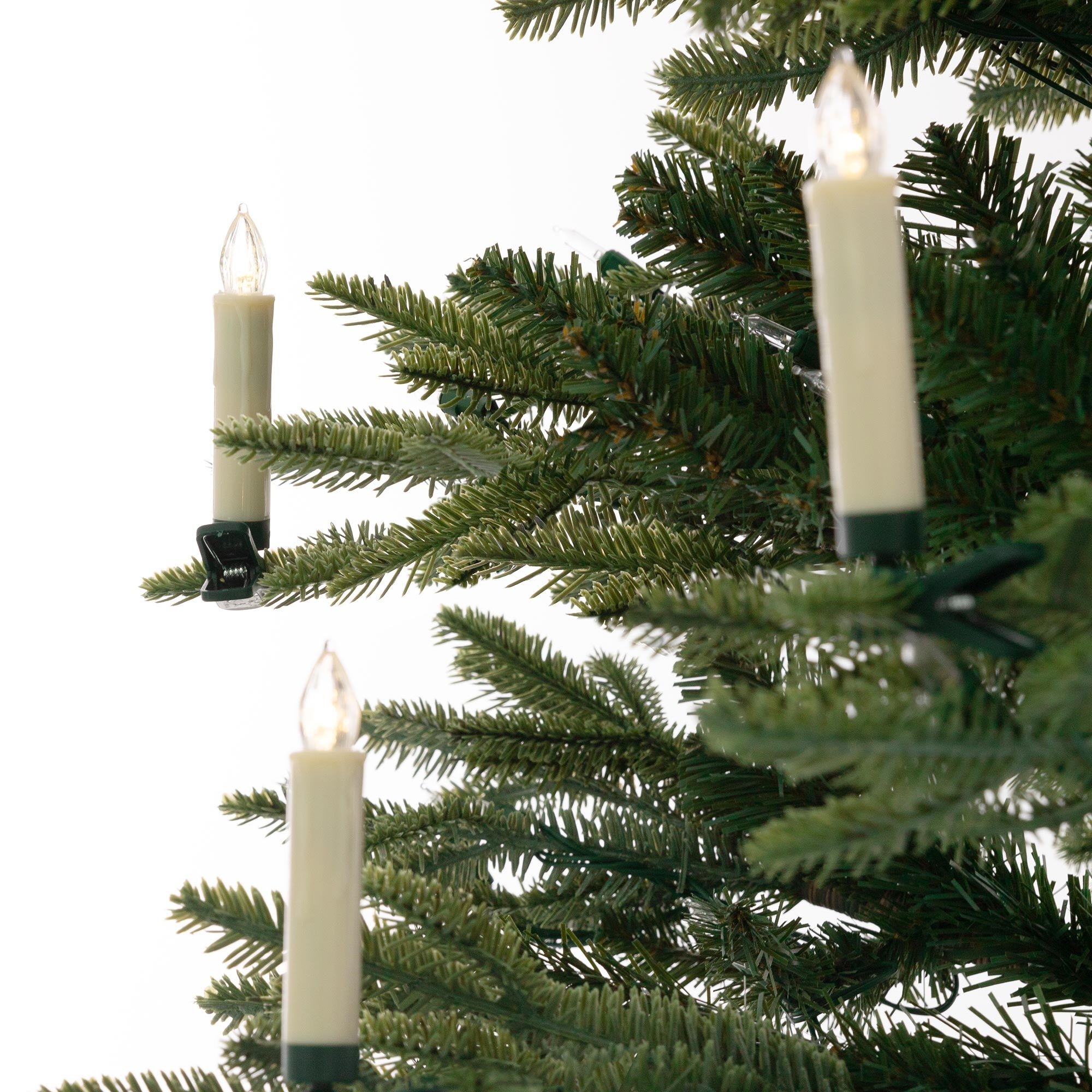 Candle lights are attached to a Christmas tree.