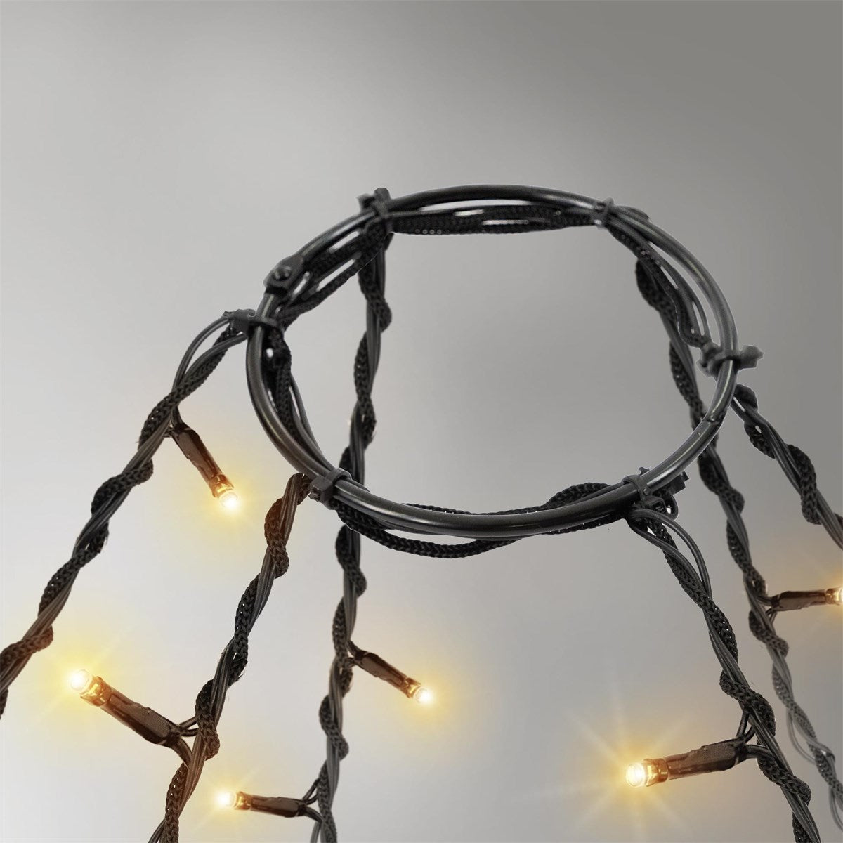 En ring med lys, der er fastgjort til et sort kabel, og som lyser blødt.