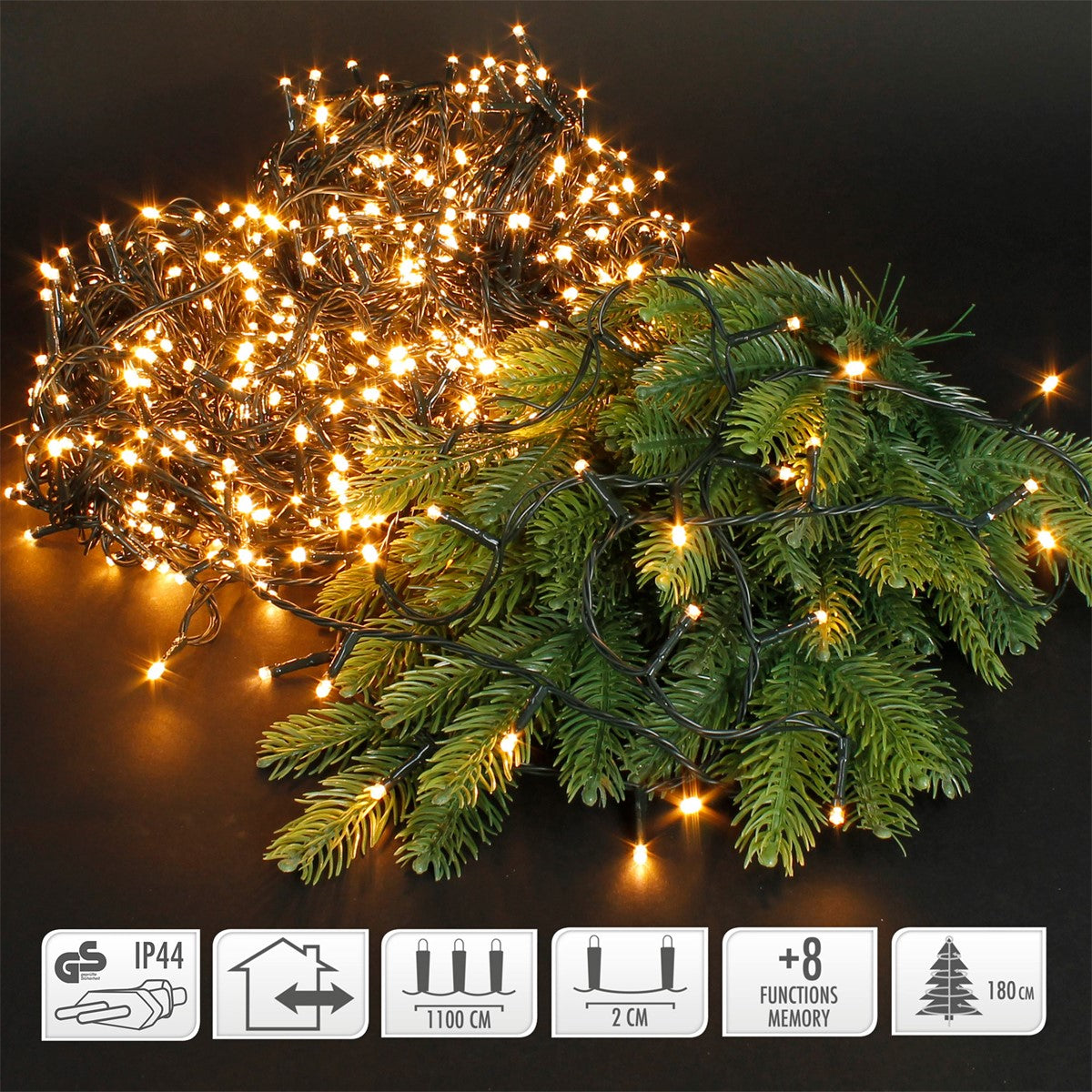 Lichterkette mit warmweißen LEDs und grünen Tannenzweigen auf schwarzem Hintergrund.