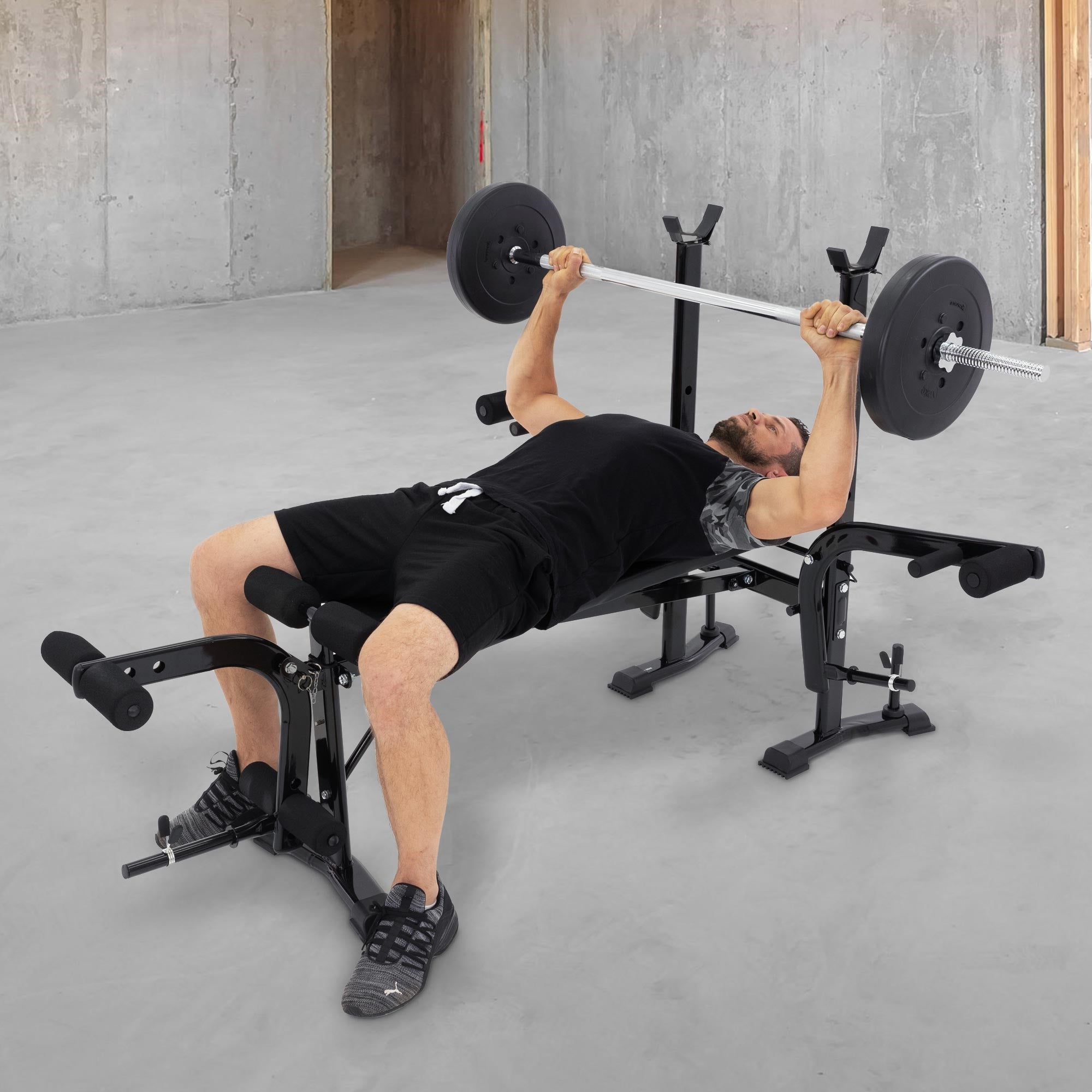 Person hebt eine Langhantel auf einer Fitnessbank.