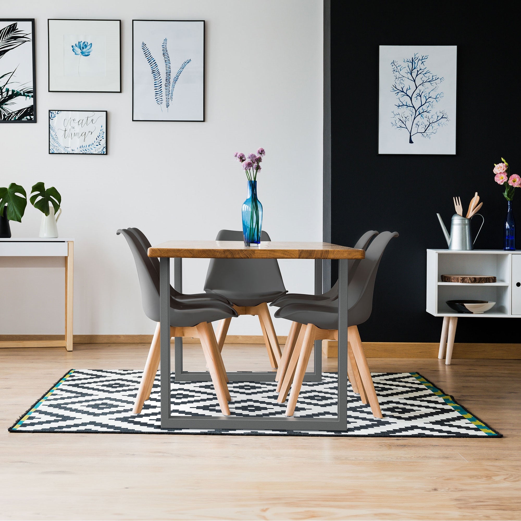 Esszimmer mit Tisch, Stühlen und Wandbildern.