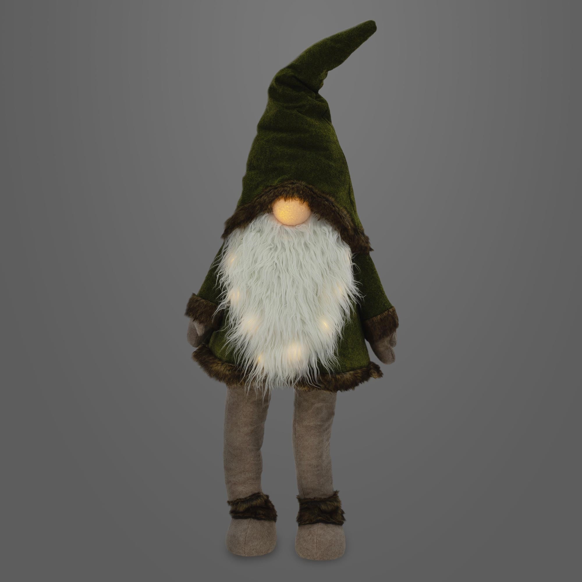 Pluche gnoom met groene hoed en witte baard, verlicht, voor een grijze achtergrond.
