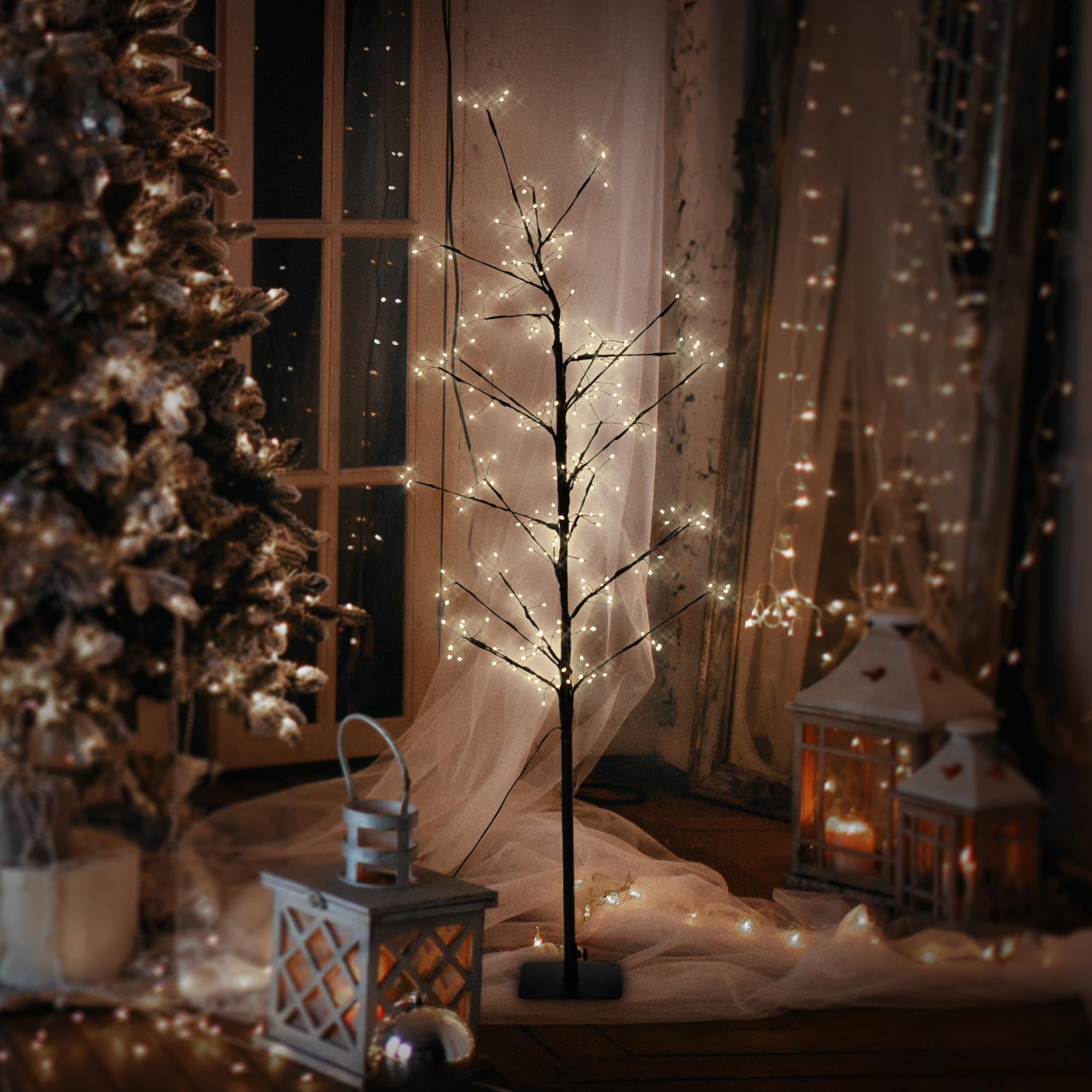 Árbol iluminado en una habitación decorada festivamente con faroles.