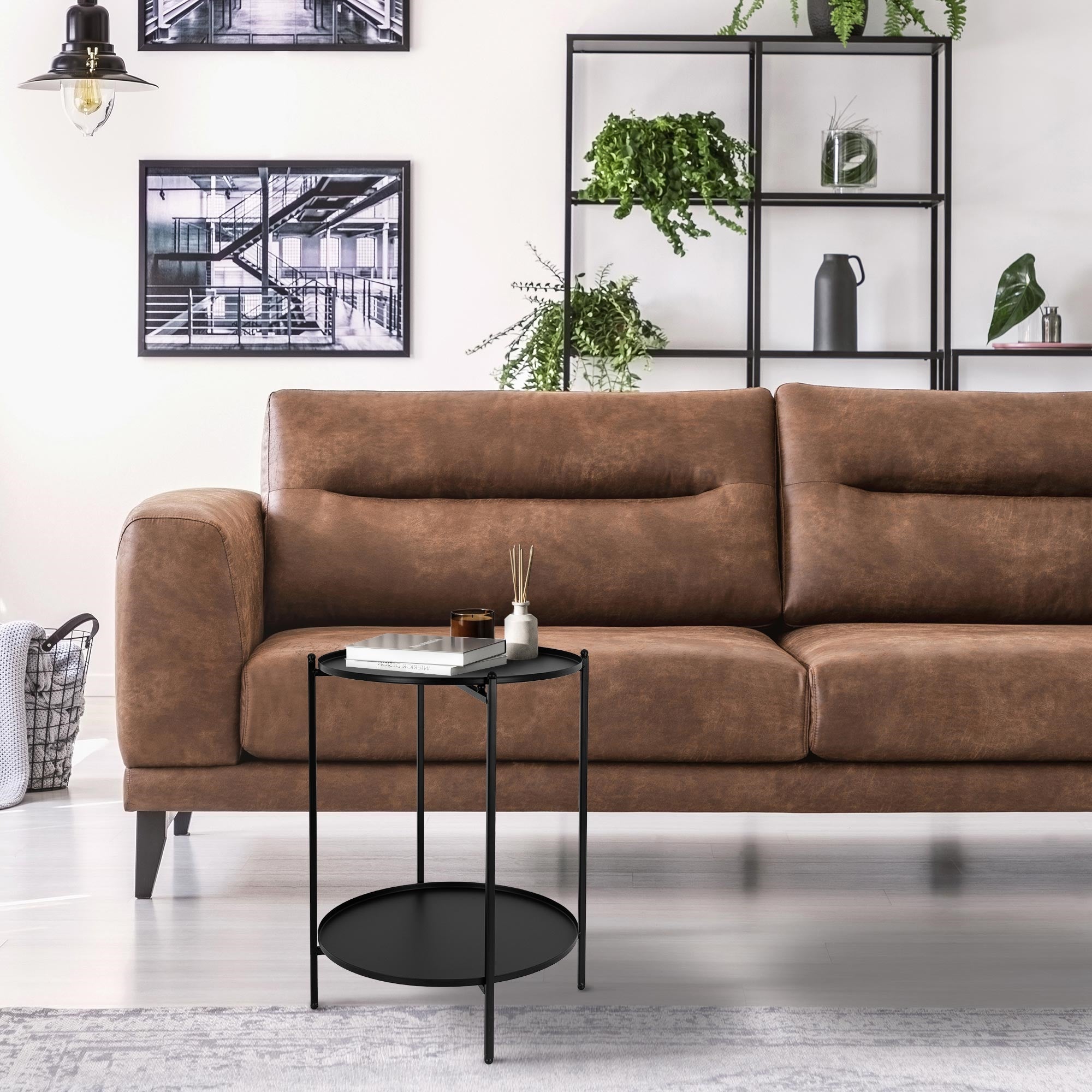 Brown sofa with two cushions and a small round table next to it.