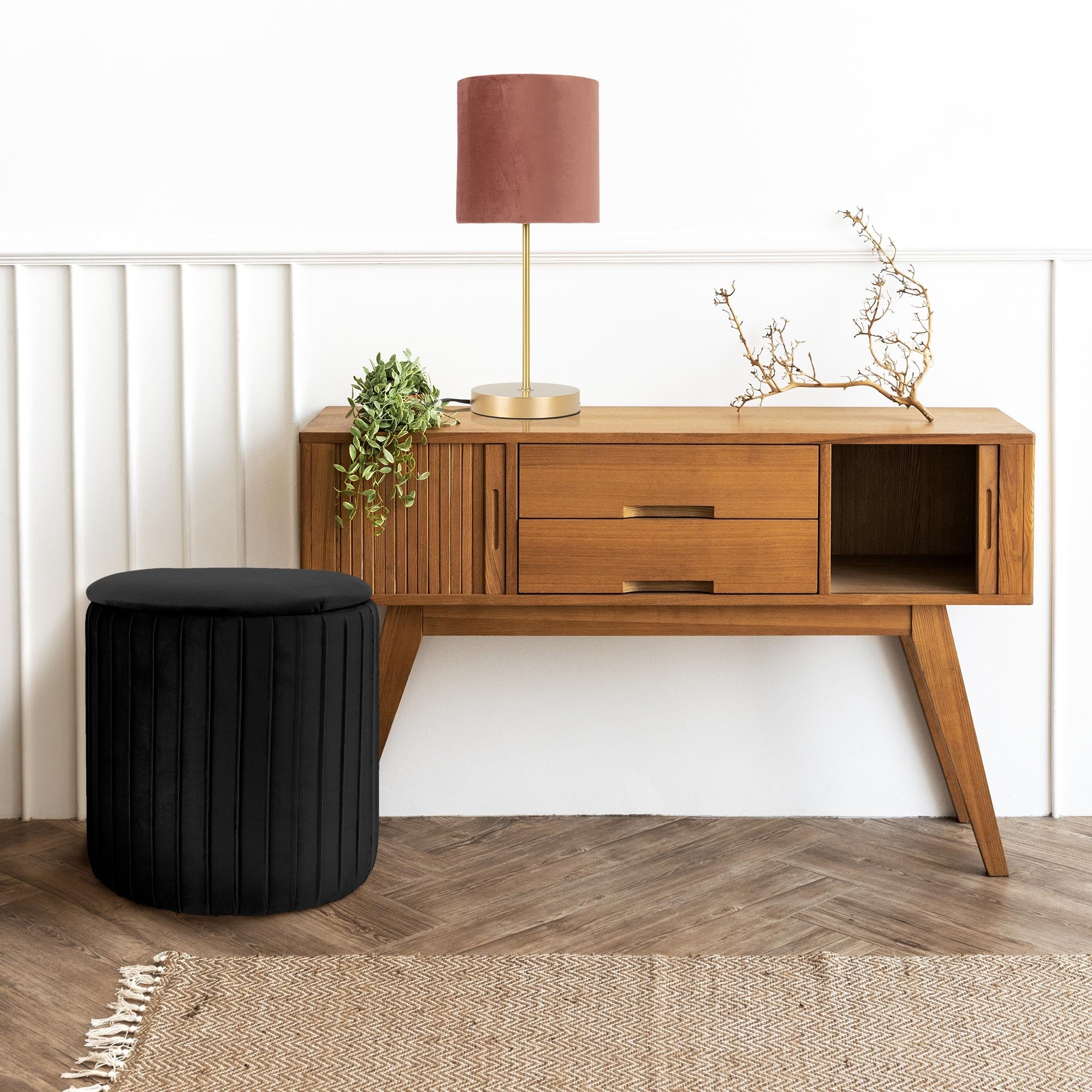 Trækommode med to skuffer, en lampe og en plante på en lys baggrund.