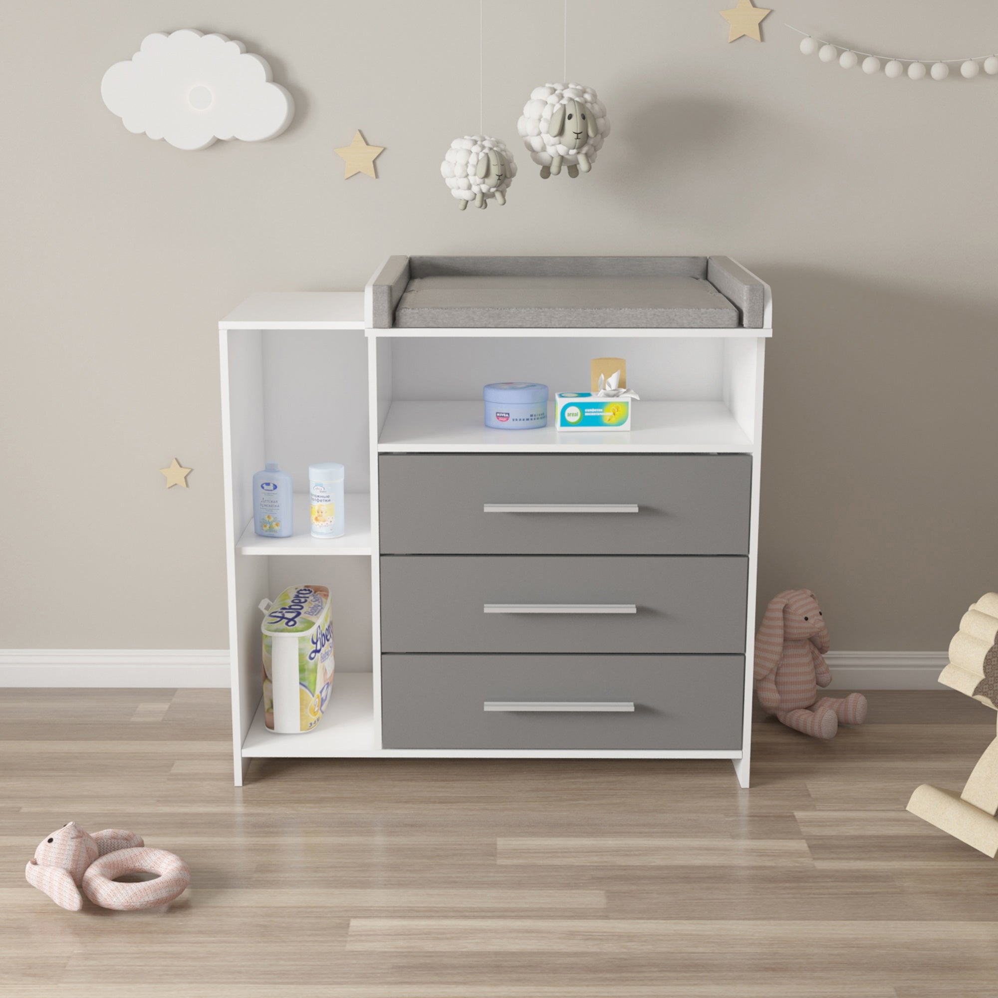 Changing table with changing pad, drawers, and toys on a floor.