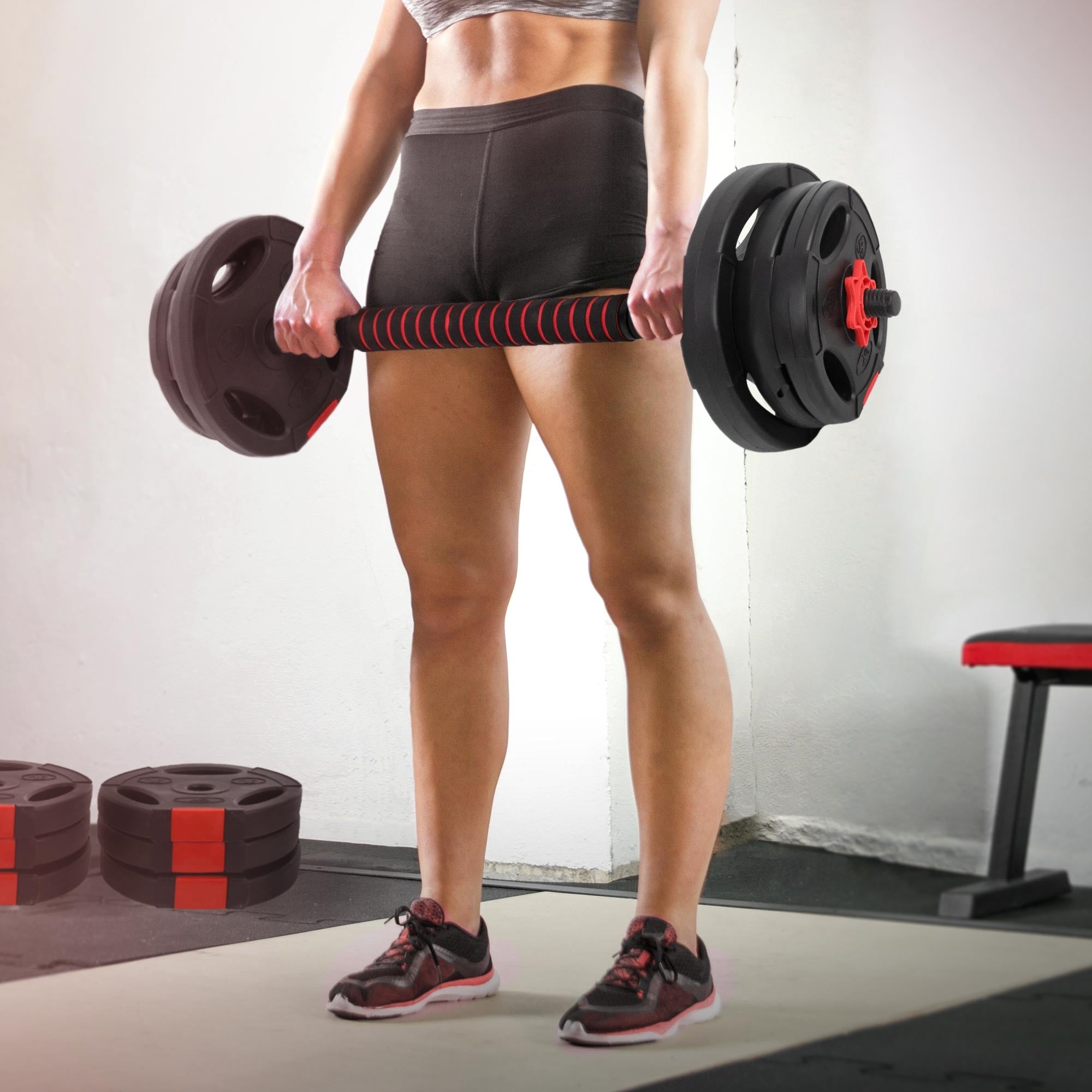Eine Person hebt eine Langhantel im Fitnessstudio.