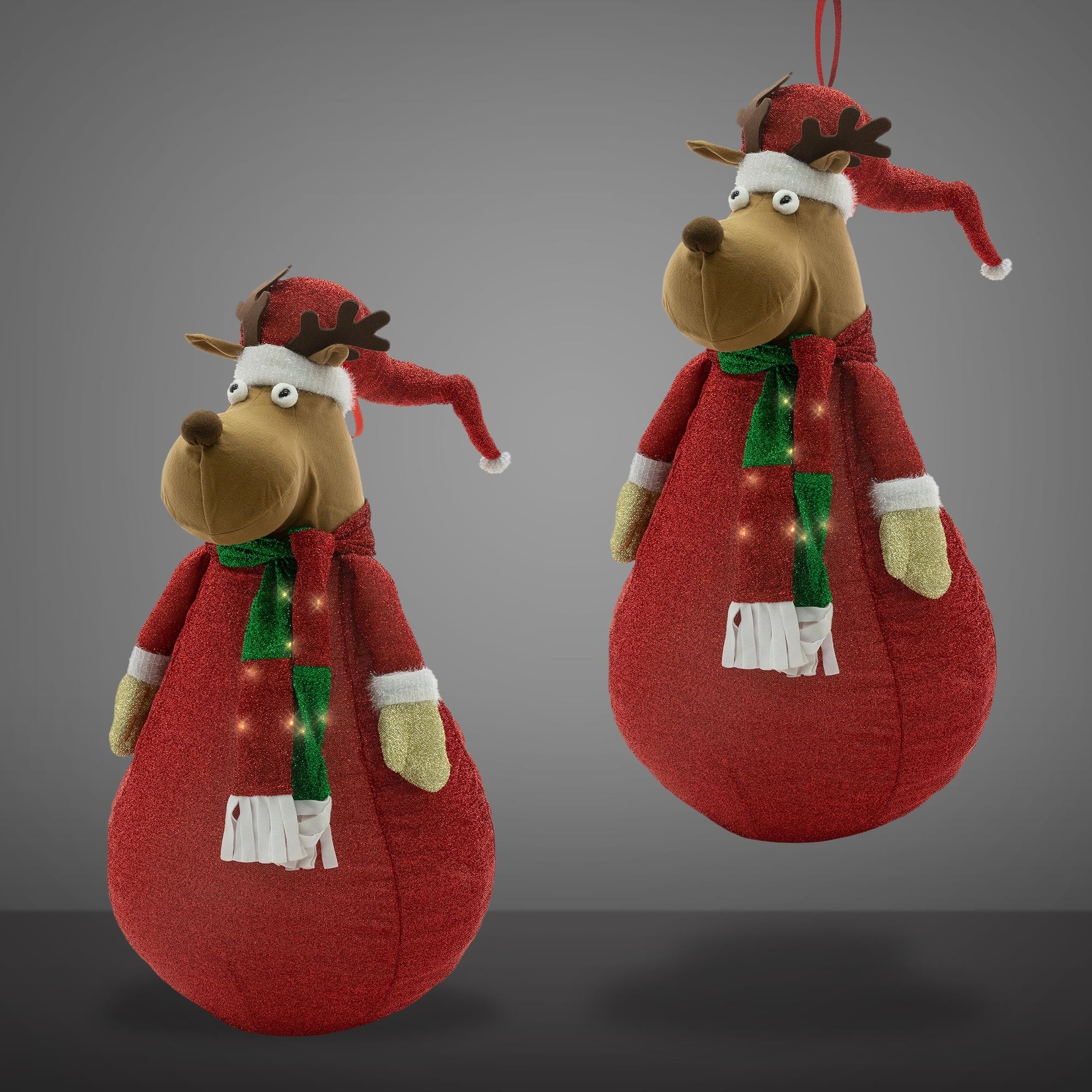 Zwei Weihnachtsmann-Dekorationen in Form von Tieren mit roten Hüten und Schals.