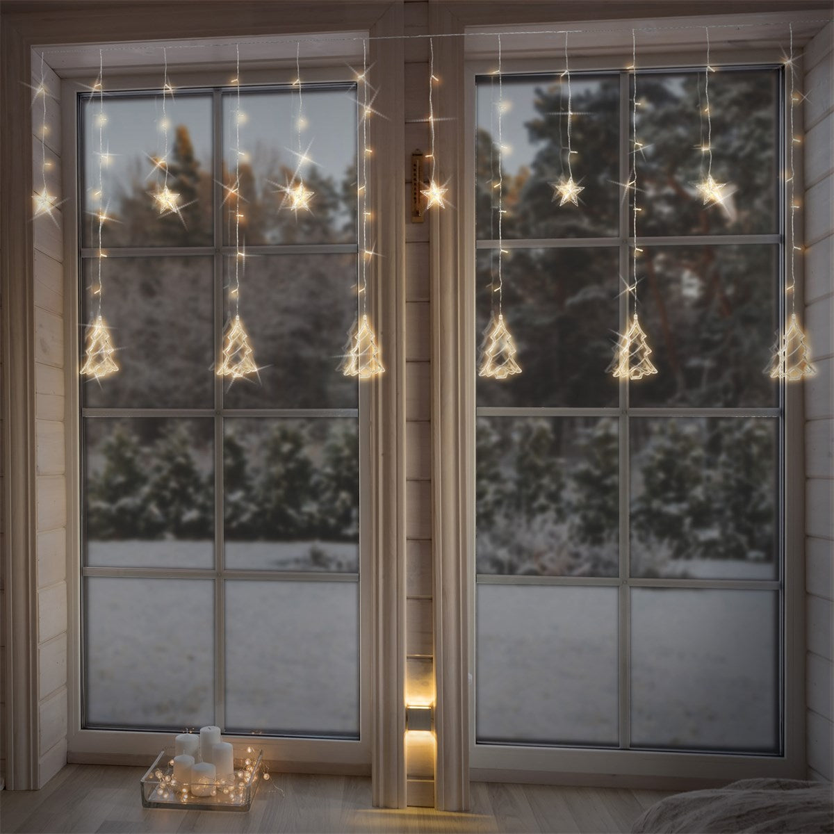 Fenster mit hängenden Lichtern in Form von Bäumen und Sternen.
