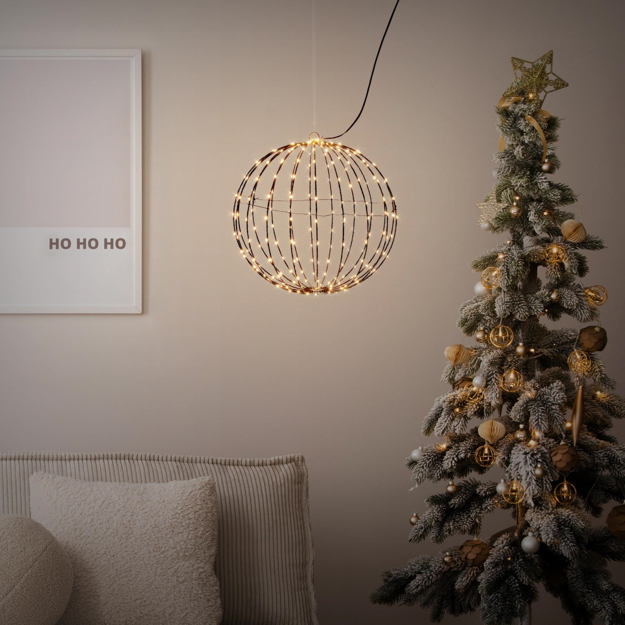 A lit Christmas tree with golden ornaments and a globe light.