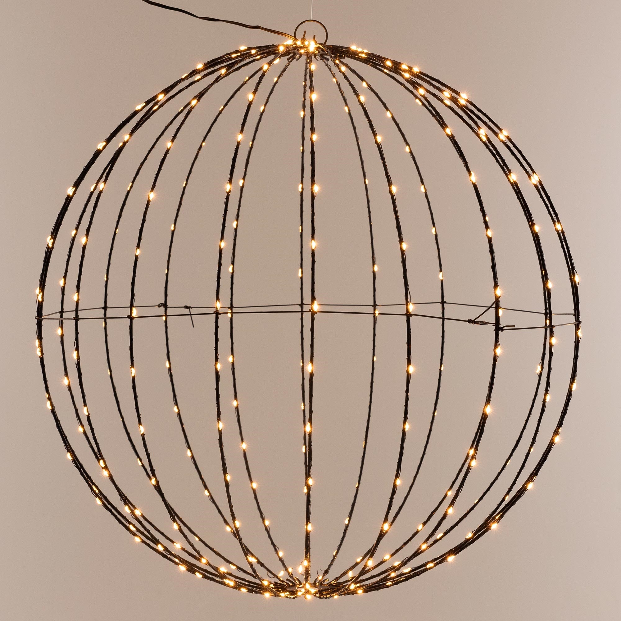 Sphere made of wire with lights, hanging on a wall.