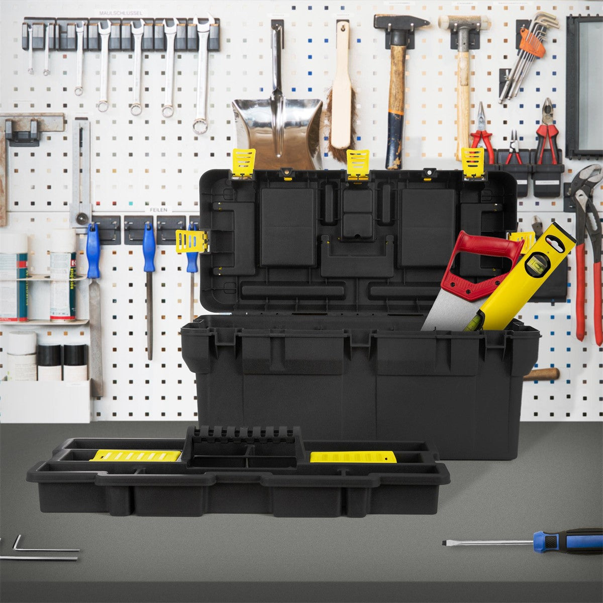 Caisse à outils noire avec le couvercle ouvert et des outils en arrière-plan.