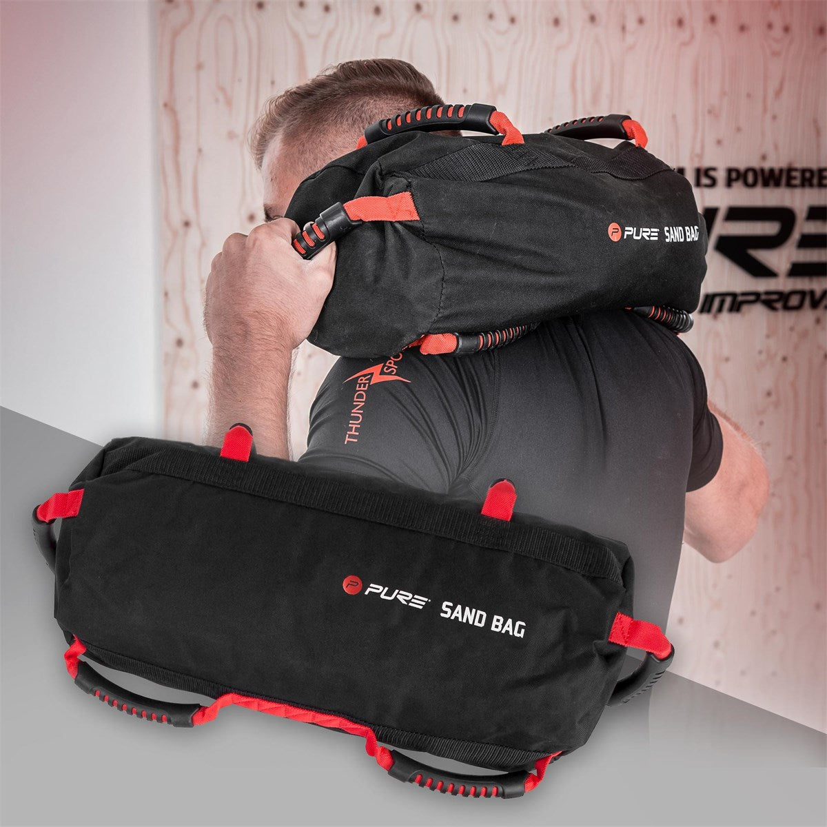 Una persona levanta por encima del hombro un sandbag negro con detalles rojos.