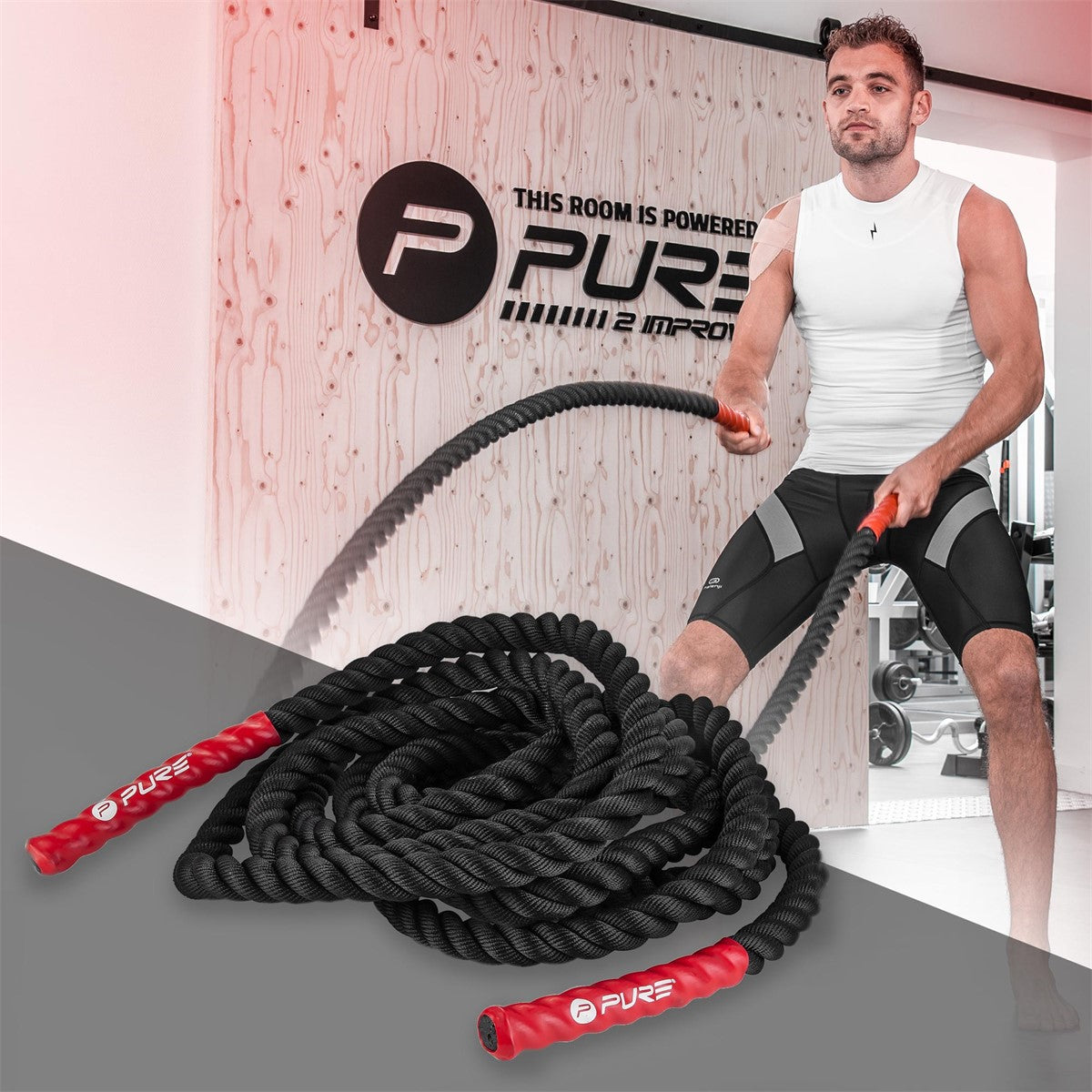 Un uomo in abbigliamento sportivo si allena con una corda in palestra.