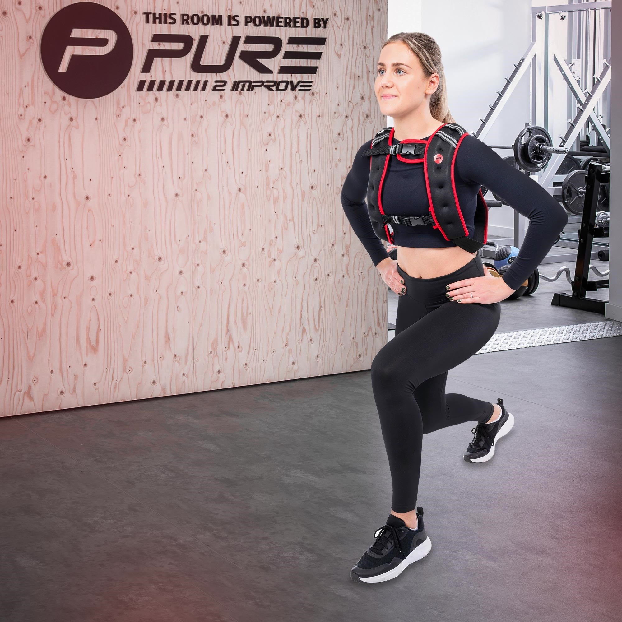 Eine Frau in Sportkleidung führt einen Ausfallschritt in einem Fitnessstudio aus.