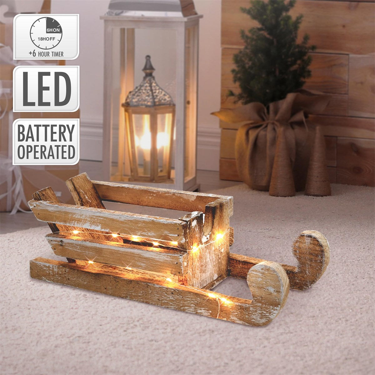 Holzschlitten mit Lichtern, auf dem Boden, neben einer Lampe.