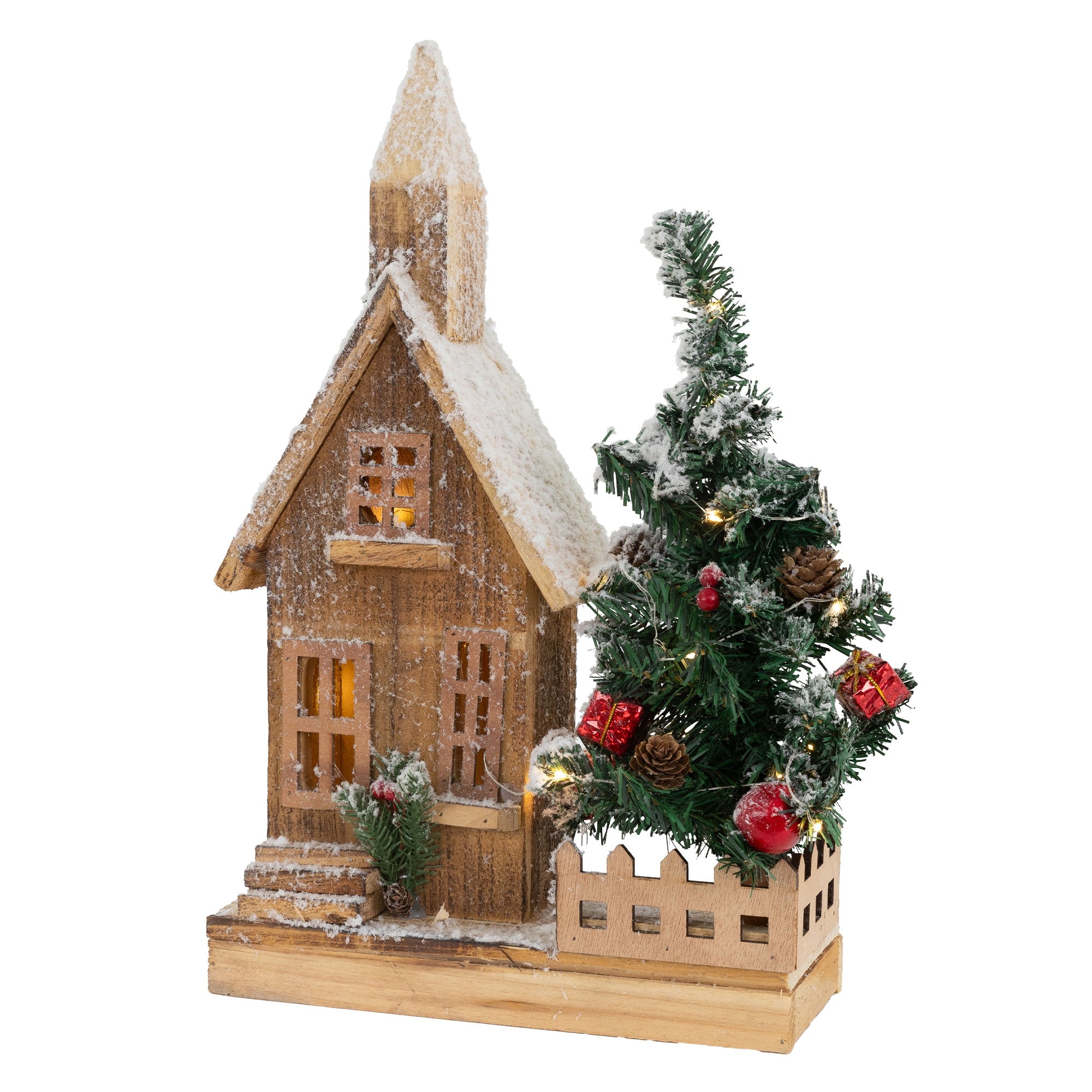 Ein Holzhaus mit Schnee und einem Weihnachtsbaum davor.