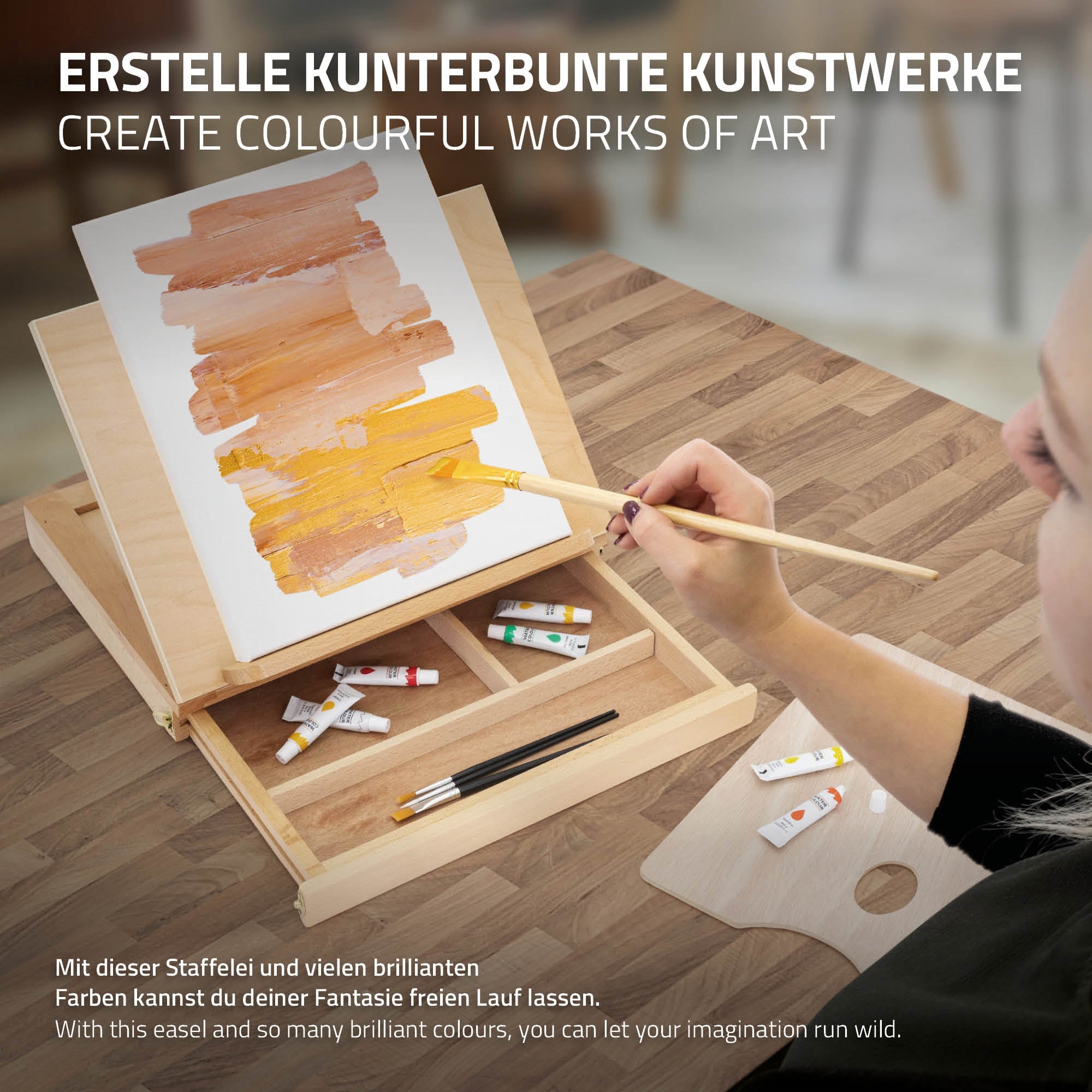 Staffelei mit bunten Farben und Pinsel auf einem Tisch.