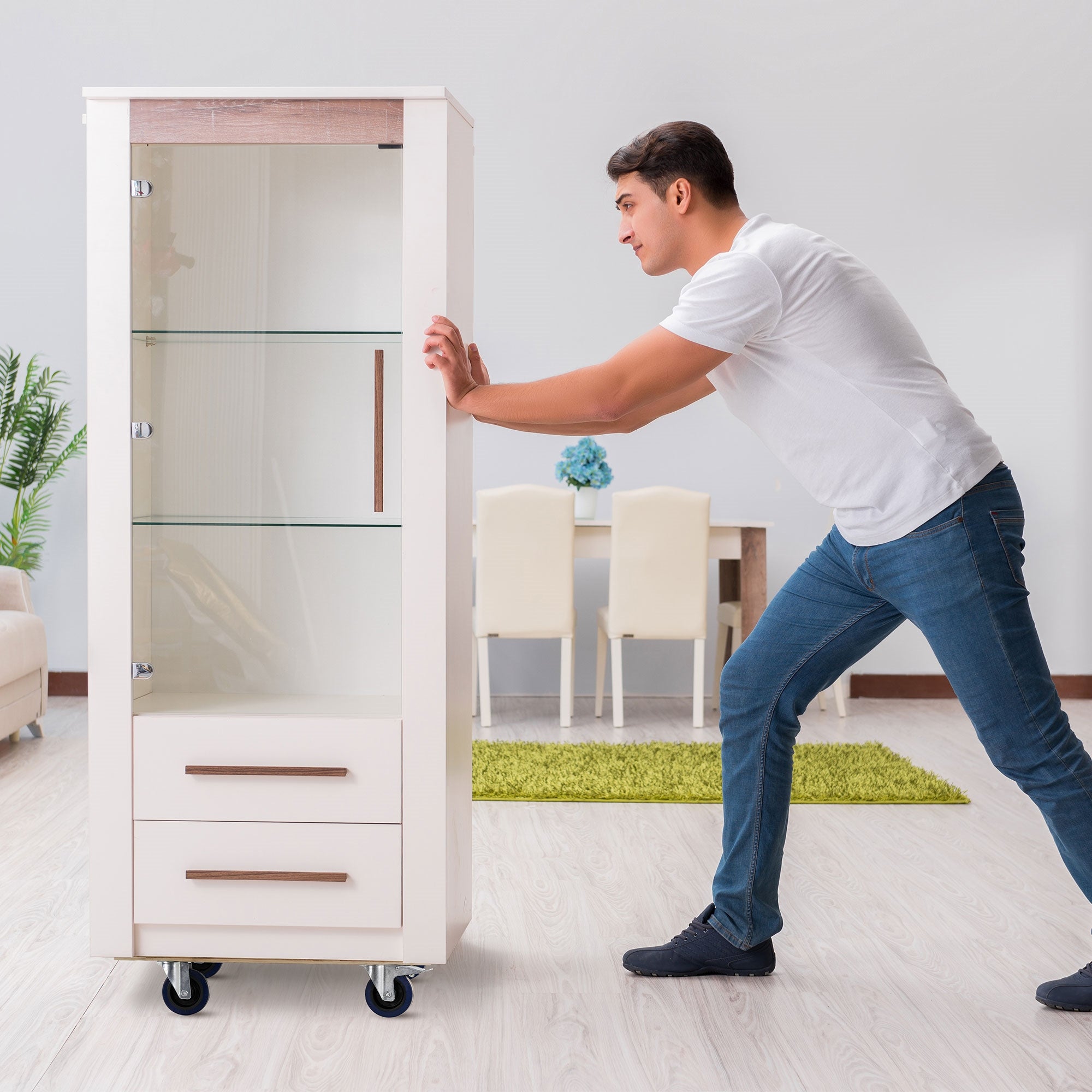 Mann schiebt einen Glasvitrinenschrank in einem modernen Raum.