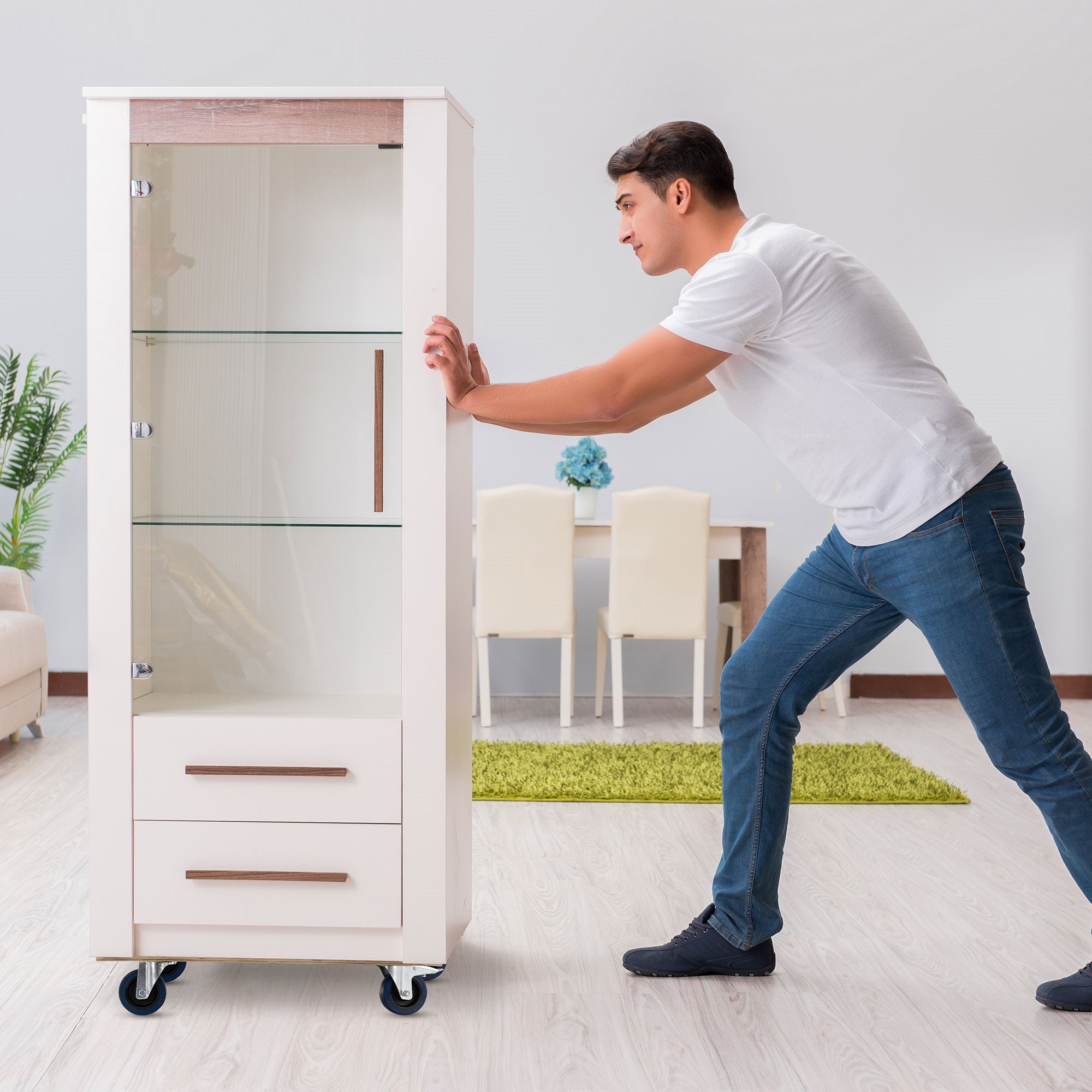 Ein Mann schiebt einen Glasvitrinenschrank in einem modernen Raum.
