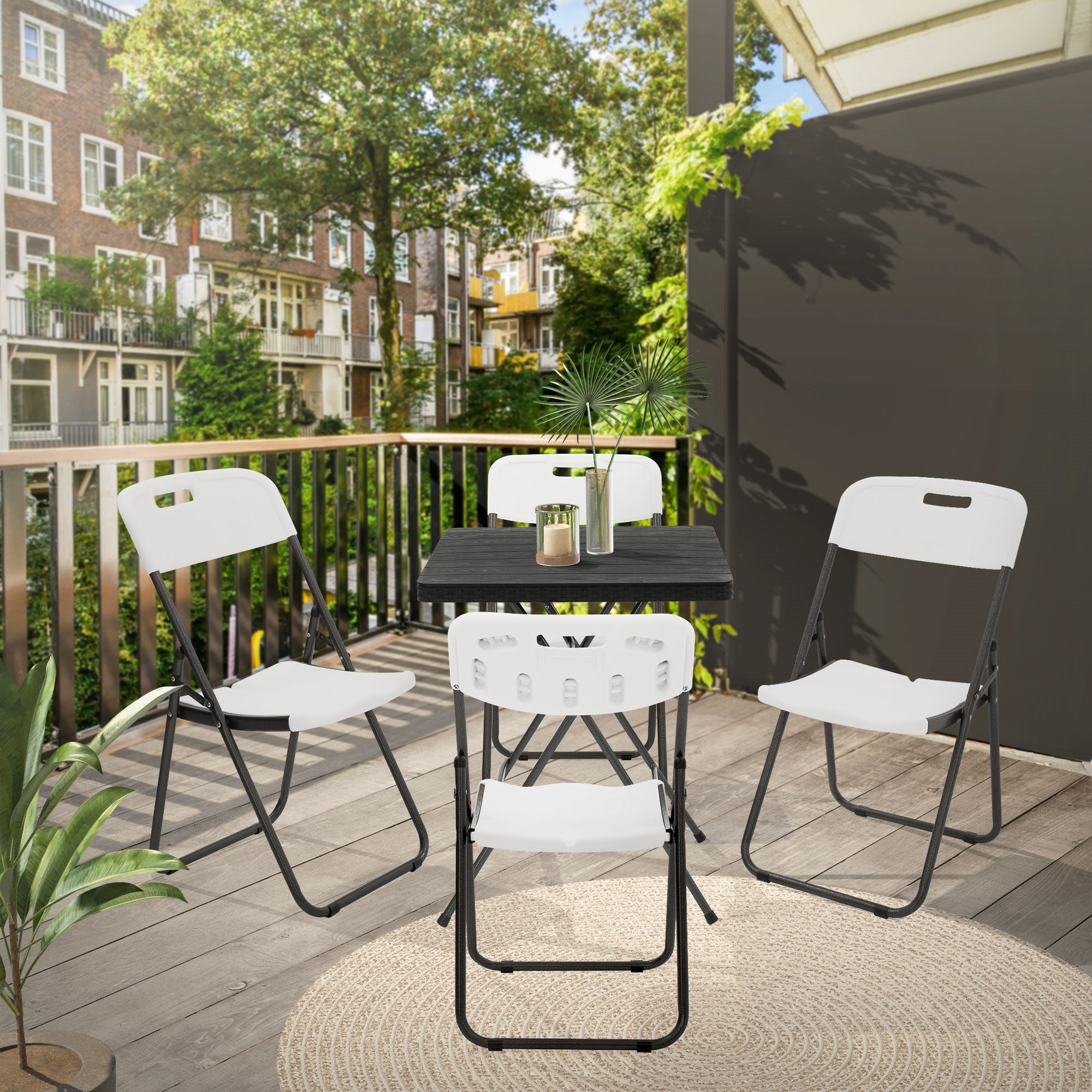 Ein Balkon mit einem Tisch und vier Stühlen, umgeben von Pflanzen und Bäumen.