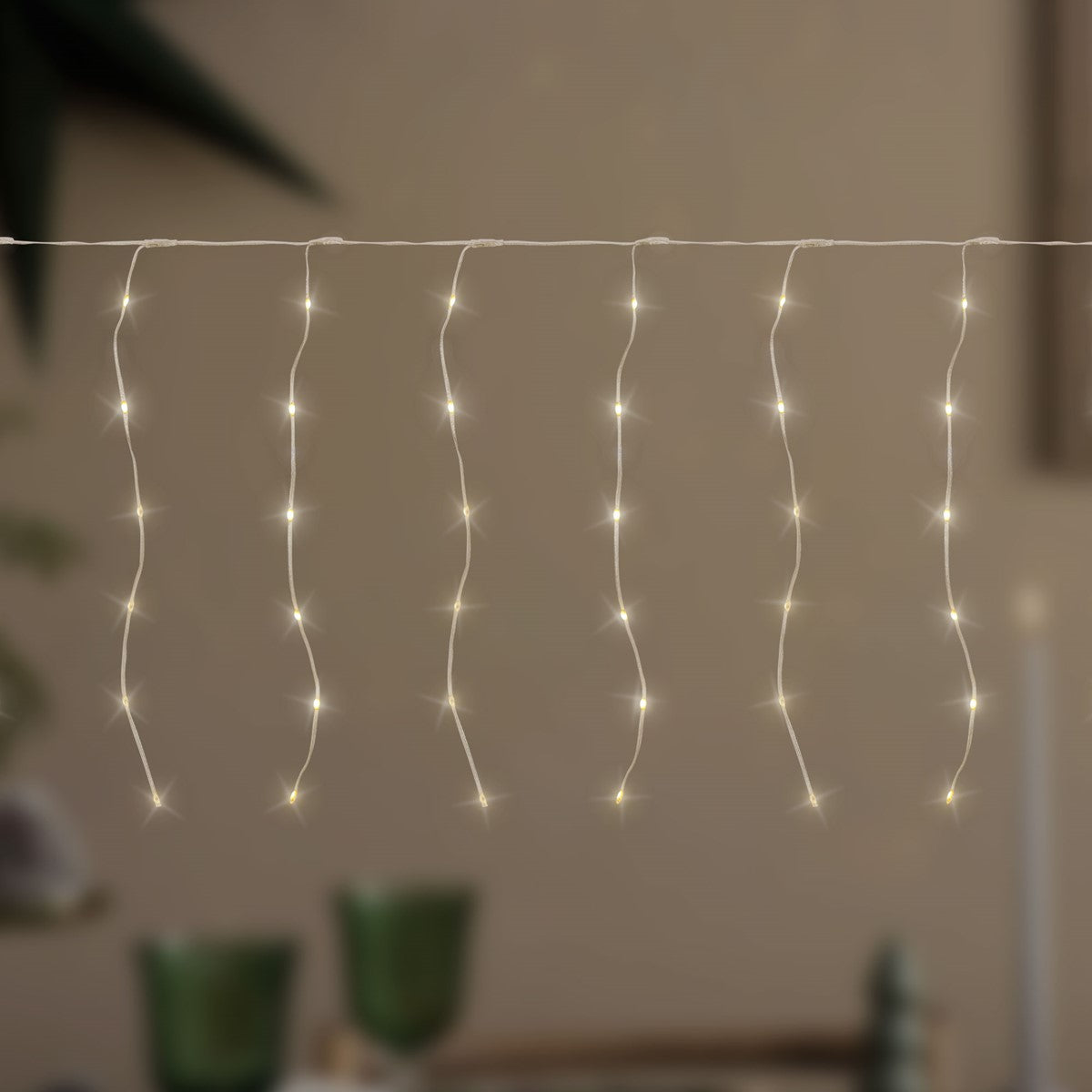 Lichterkette mit warmweißen Lichtern, die in verschiedenen Höhen hängen.
