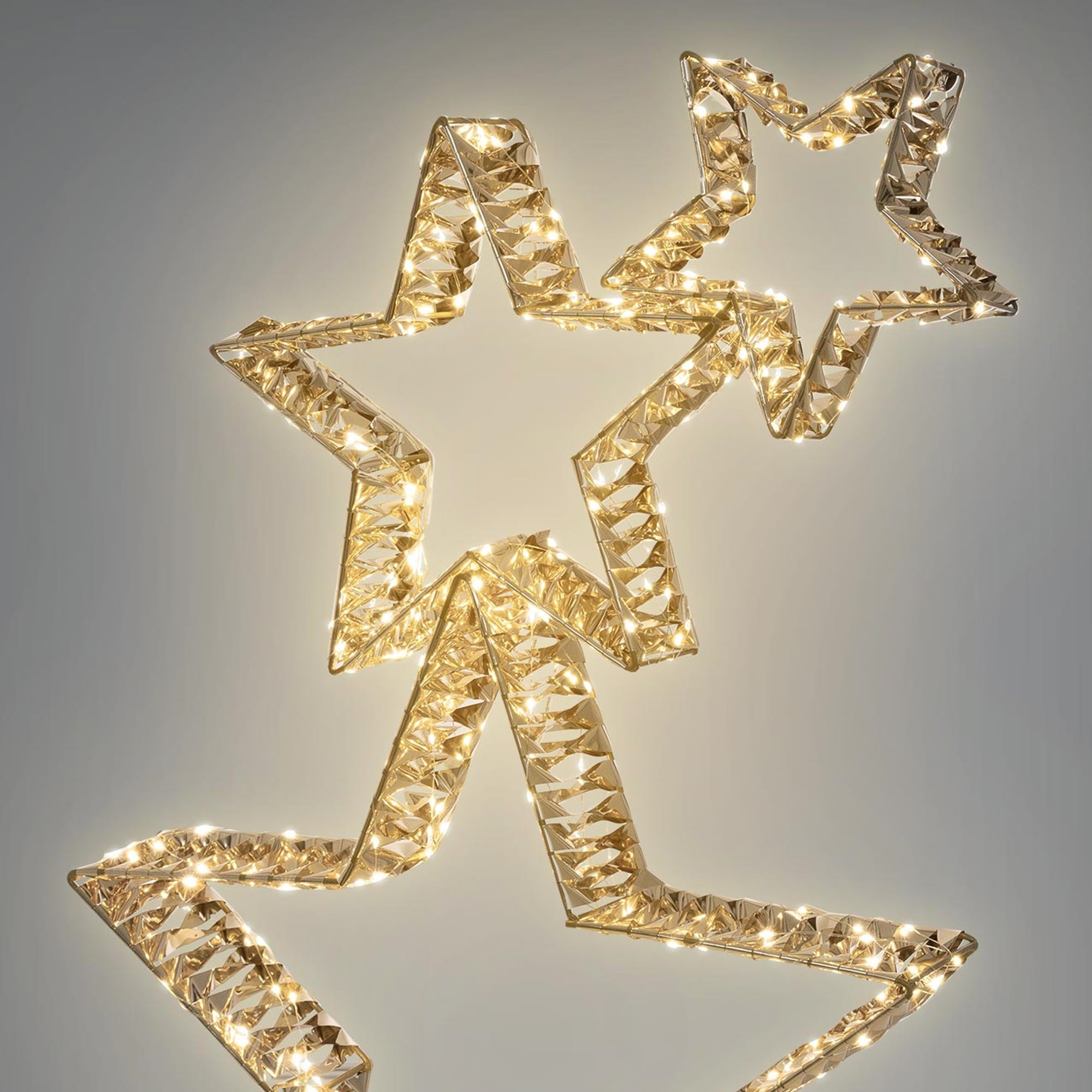 Estrellas doradas con luces, sobre un fondo gris.