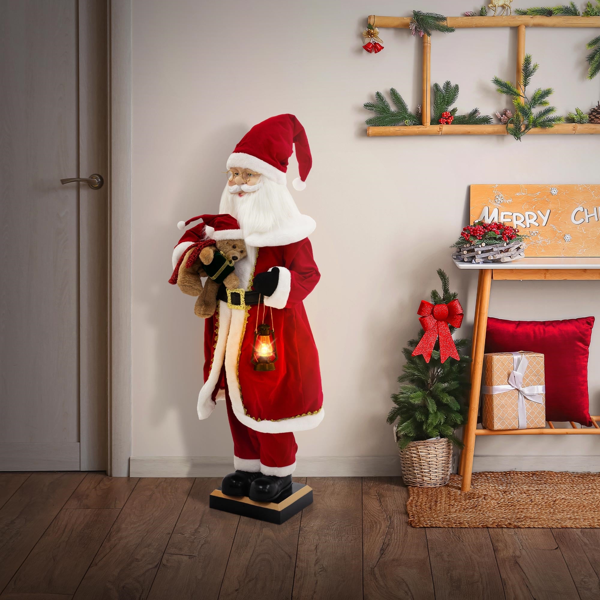 Weihnachtsmannfigur in einem Raum, die ein Stofftier und eine Laterne hält, neben einem Weihnachtsbaum.