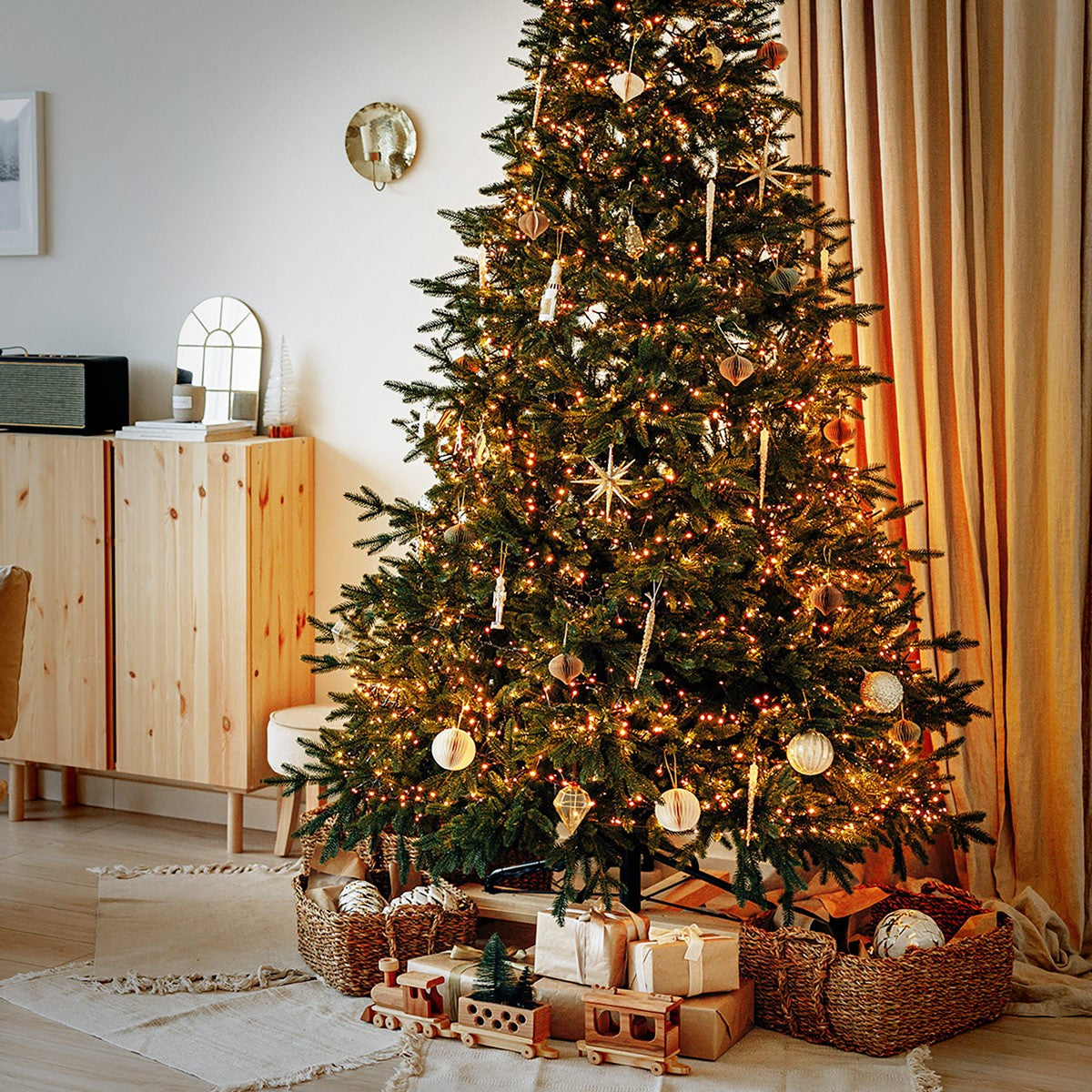 Ein geschmückter Weihnachtsbaum mit Lichtern und Geschenken darunter.