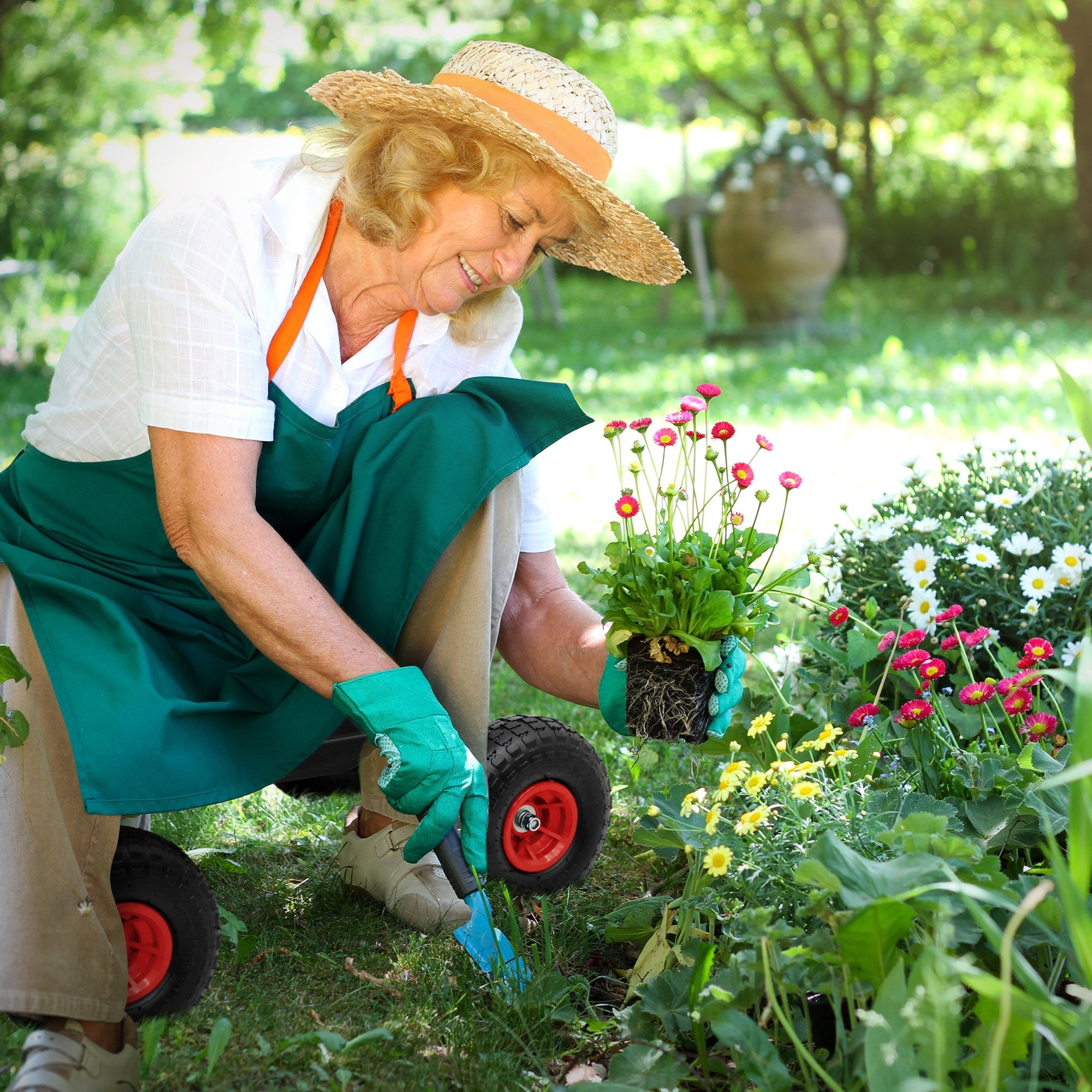 Donna anziana che pianta fiori in giardino, indossa un cappello e guanti.