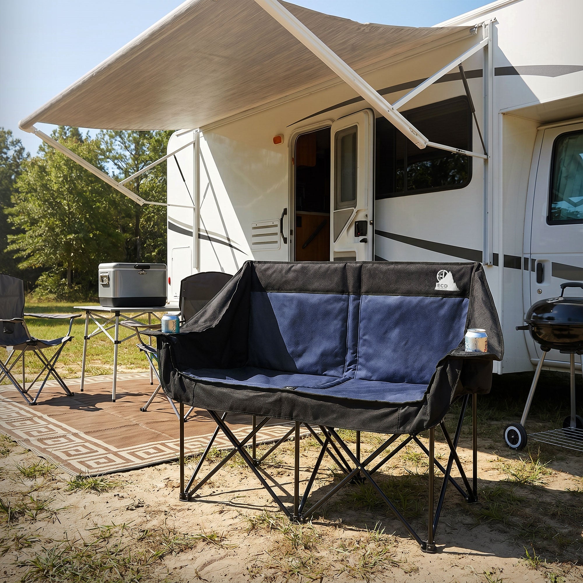 Campingstuhl vor einem Wohnmobil mit Tisch und weiteren Stühlen.