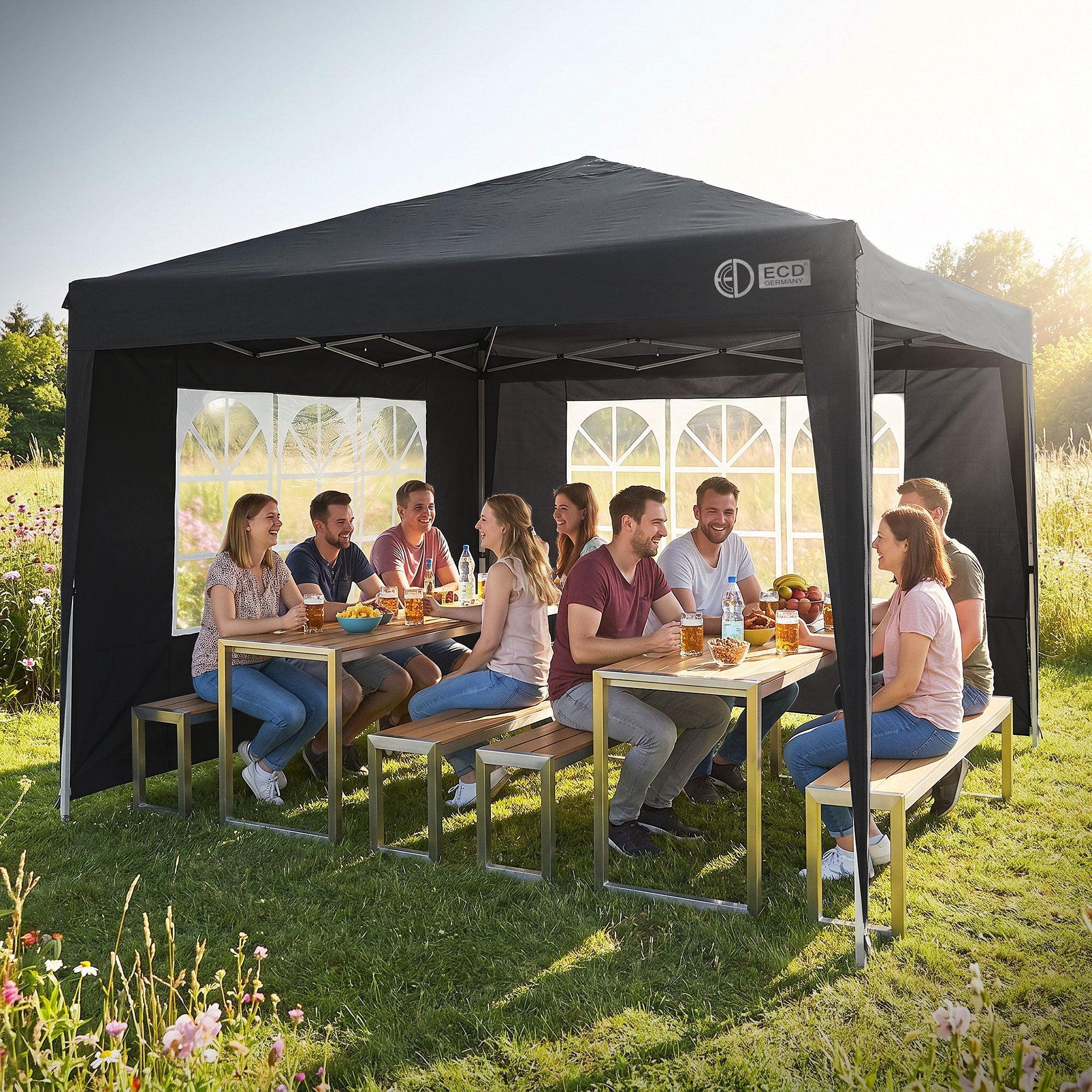 Gruppe von Menschen sitzt unter einem Pavillon und genießt ein Picknick.
