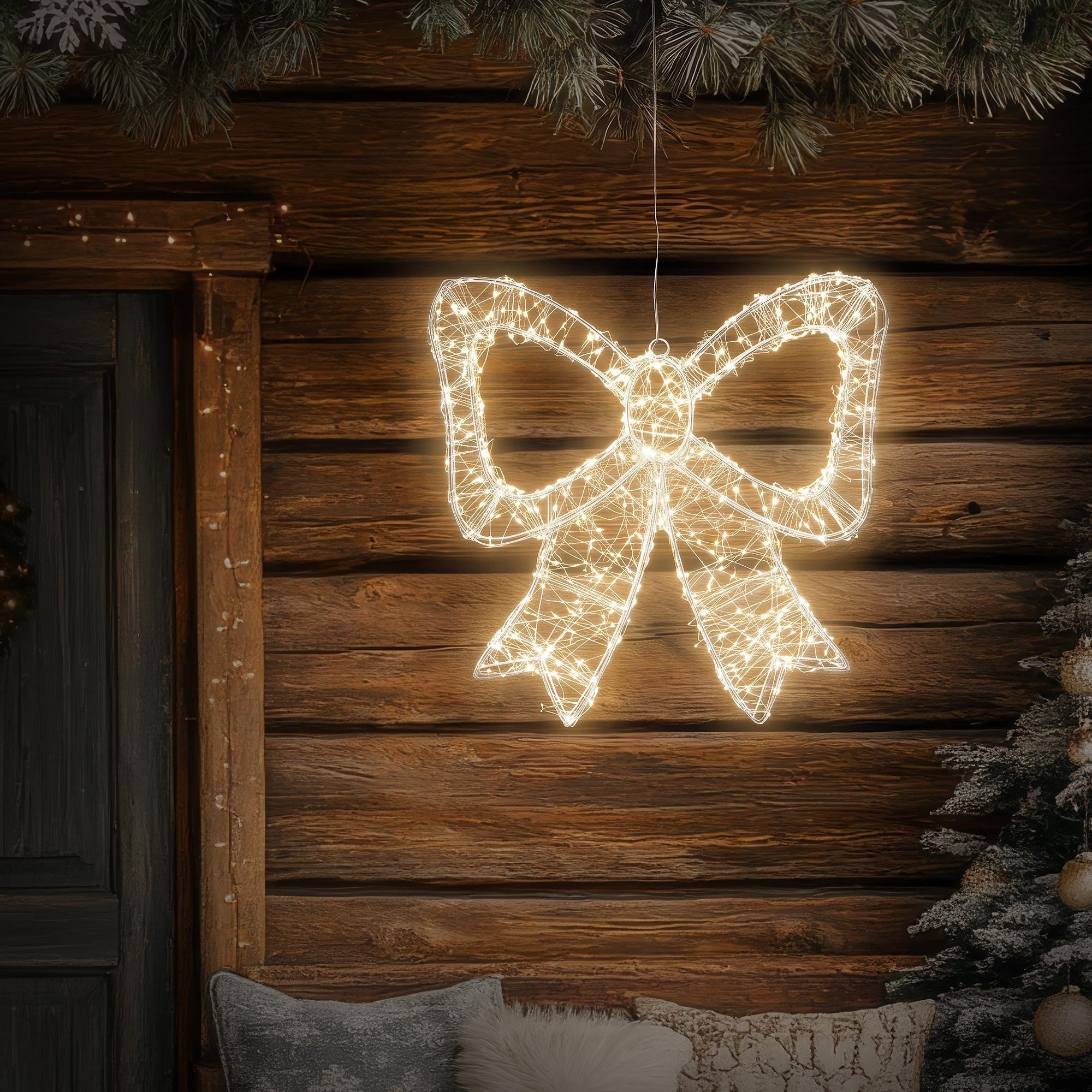 Glowing Christmas decoration in the shape of a bow in front of a wooden wall.
