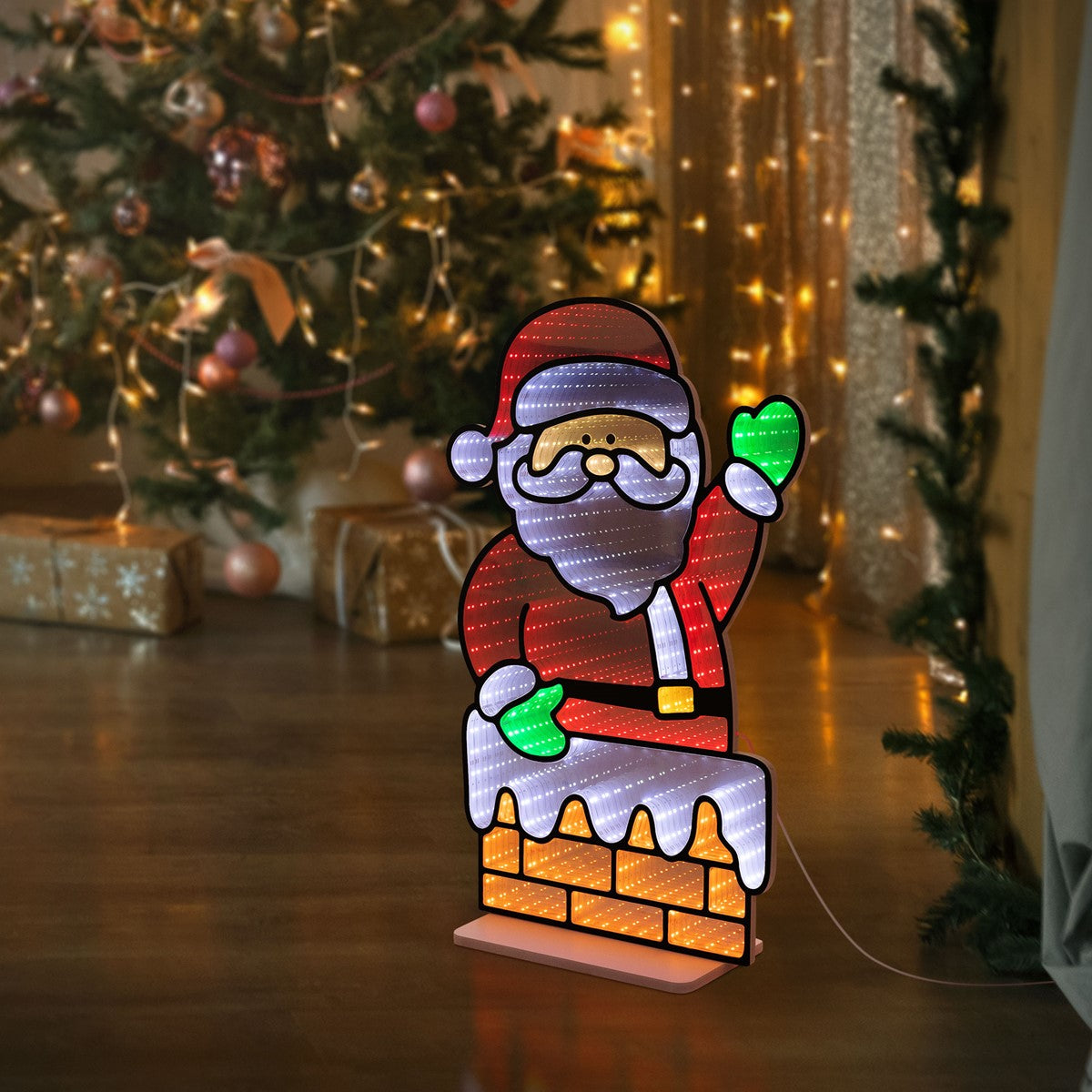 Weihnachtsmannfigur mit rotem Hut, vor einem geschmückten Weihnachtsbaum.