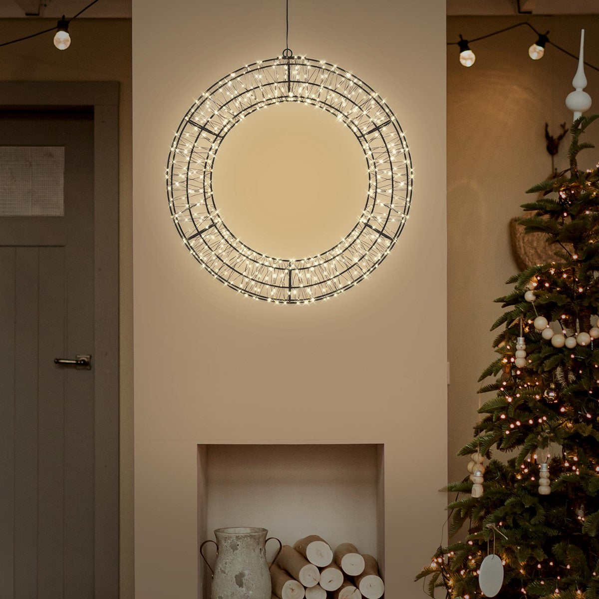 LED-Kranz hängt in einem Raum neben einem Weihnachtsbaum.