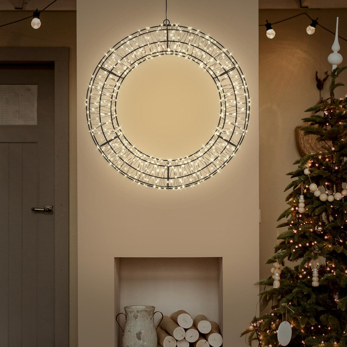 Runde LED-Lampe hängt in einem Raum, Weihnachtsbaum im Hintergrund.