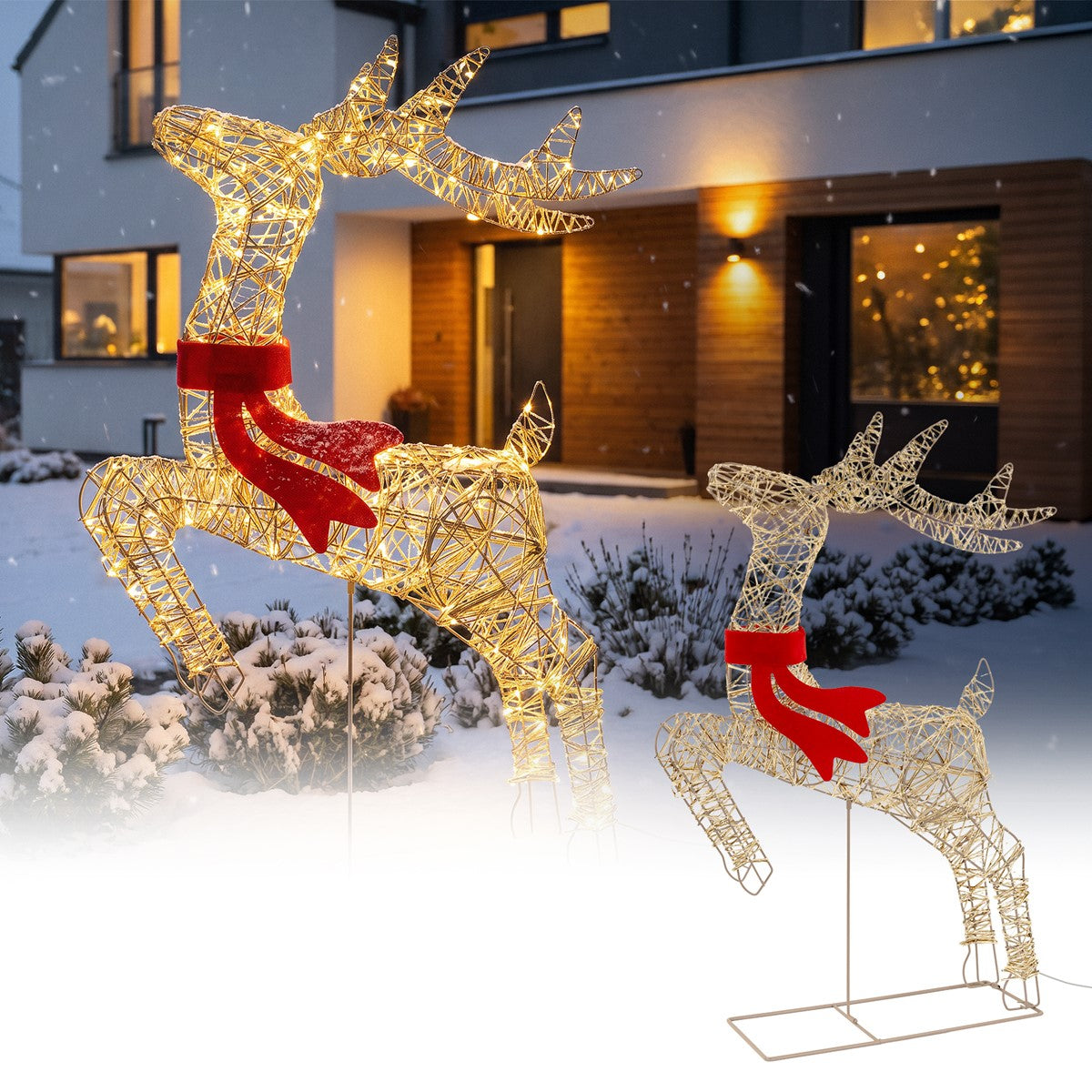 Deux figurines de rennes lumineuses dans la neige devant une maison moderne.